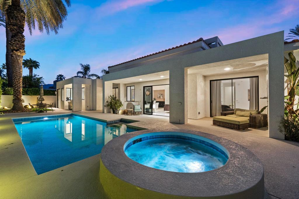 Your desert retreat awaits in Mission Pointe. This architectural modern home features 3 bedrooms, 4 baths, and a courtyard entry on a 10,000+ sq ft lot with beautifully landscaped grounds and designer outdoor lighting. A pebble tech pool and spa are surrounded by mature palms, greenery, and generous lounge areas, creating a private outdoor oasis.Inside, Italian porcelain tile floors flow through high-ceilinged spaces, including a dramatic 16-ft living room with a custom fireplace accented by Michael Aram handmade tile. Walls of glass sliders connect every room to multiple outdoor living areas. A Palm Springs-style sunken bar anchors the open living/dining/entry gallery, while the island kitchen offers leathered stone countertops, premium appliances, and an adjoining breakfast/lounge area.Each of the three ensuite bedrooms includes a walk-in closet. The main suite features a custom-lit California Closet and spa-like bath with Italian mosaic tile. Additional highlights include designer finishes, LED art lighting, and an immaculate two-car garage with epoxy floors, built-in storage, and a dog wash station. Low-HOA community amenities include a fitness center, pickleball, and tennis. Centrally located with easy access to Palm Springs and the valley's best, this former model home is move-in ready.