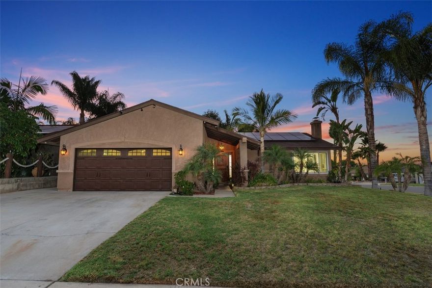 As you step into this resort-style retreat, you’re greeted by light, space, and the feeling that every day could be a getaway. Beautifully updated throughout, this single-story home features a custom rock pool and spa on a premium corner lot with gated RV parking — with the possibility to create an ADU (buyer to verify with the City of Corona), opening doors for multigenerational living or added income. LOW TAXES & NO HOA keep ownership simple. Inside, the open-concept design flows effortlessly across 1,624 sq. ft. with four bedrooms and two bathrooms. The newly added custom kitchen island and extra storage is a chef’s dream, paired with stainless steel appliances and seamless connection to the vaulted great room with cozy fireplace, LED lighting, and new LVP flooring (2025). Step outside to your private resort-like backyard oasis — a stunning rock pool and spa with waterfall and PebbleTec finish, a covered patio with TV, firepit, lush tropical landscaping, stamped concrete, accent lighting, storage shed, and gated dog run an entertainers dream. Thoughtful upgrades include a newer roof, new water heater (2025), newer dual-pane windows, newer HVAC, fresh interior paint (2025), a custom front door, mirrored wardrobes, smooth ceilings, solar panels, and elegant shutters. The primary suite opens directly to the backyard and features a luxurious walk-in rock & stone shower, while three additional bedrooms offer flexible living space. With welcoming curb appeal, a two-car garage with extended driveway parking, and ready for RV hookups, this home is move-in ready and built for the way you want to live. Close to schools, shopping, dining, and easy freeway access — it’s peaceful, bright, and ready to make everyday living (and unforgettable gatherings) feel effortless.