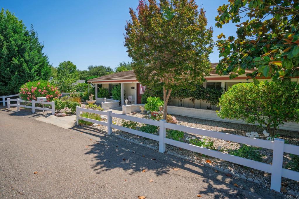 Welcome to 3519 Cherrybrook Court—a hidden gem tucked away in the heart of Fallbrook’s scenic Gird Valley. This charming single-story ranch-style home offers 2 bedrooms, 2 bathrooms, and 2,024 sq ft of living space on a generous 10,357 sq ft lot. Set on a quiet cul-de-sac, this property offers rare privacy and stunning backcountry vistas. The curb appeal is warm and inviting with low-maintenance landscaping and a sweet, country feel. Step through the double beveled-glass entry doors into an open floor plan filled with character: vaulted ceilings with exposed beams, a cozy fireplace framed by an adobe brick wall, and a formal living room perfect for relaxing or entertaining. The kitchen features a center island and opens to a nearly full-length sunroom—ideal for enjoying morning coffee or afternoon breezes year-round. The spacious primary suite includes French doors that open to a patio with a breathtaking view, a walk-in closet, and a beautiful custom walk-in shower. The second primary suite is light-filled and comfortable, perfect for guests or a home office. The property offers a peaceful escape with fruit trees galore—Asian pears, lemons, figs, and oranges—as well as two storage sheds and a bonus space that makes a wonderful yoga studio, art room, or office. Meander through the backyard and discover your own secret garden tucked into the landscape. Live Oak Estates provides a tranquil, country living experience and is just a short stroll from Monserate Winery. You'll enjoy access to top-tier vineyards, local trails, and Fallbrook’s unique small-town charm. This is your chance to live in the heart of "Vineyard Valley," where every day feels like a getaway. All this, yet conveniently close to Fallbrook's shopping and dining. Only 2 miles north of the 76, 5 minute drive the the I -15, and 30 minutes to the Oceanside Harbor! Let the fun begin!