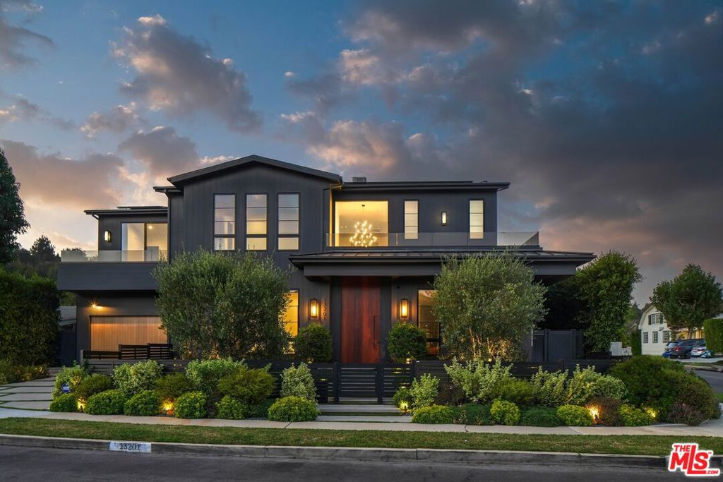 13201 Haney Place, located in the heart of Brentwood, is a stunning contemporary farmhouse boasting over 6,700 square ft, 5 bedrooms/6 bathrooms, a theatre, detached 1 Bedroom ADU, and a pool. A short distance from Paul Revere Middle School and the Brentwood Country mart and tucked away on a cul-de-sac, this beautiful house is the perfect blend of high design, seamless flow, and family living. Upon entering through the large wood door, you are greeted by the spacious living room with black marble fireplace, and an adjacent dining room big enough for a 10-foot table. Walls of windows offer beautiful natural light, a compliment to the lovely wrought iron chandelier in the middle of the dining room. Separated by an oversized wood counter and built-in floor to ceiling shelving, is the open concept family room with black marble fireplace and a wall of marble ledge seating. Opposite the large family room is the ideal chef's kitchen with an oversized double island, Thermador appliances and wall-to-wall cabinetry, offering plenty of storage. The wide counter with sink and prep area on one side and a built-in live edge table on the other offer counter seating large enough for 8. The wall-to-wall pocket doors off the family room lead to the private backyard with an outdoor barbecue, pool, spa and ADU. The ADU includes a bedroom, small kitchen, full sized bathroom and living area. With its own walkway and separation, the ADU makes for the perfect guest house. Off the kitchen is a large walk-in pantry, movie theatre, and office. Also downstairs, is a large powder room and a well sized en-suite bedroom in the front of the house offering separation from the common area. The wide staircase with walnut railing leads you upstairs to a wall of built-in bookshelves, four en-suite bedrooms and laundry room. Both corner bedrooms have sliding glass pocket doors opening to balconies. The primary bedroom includes a very large bathroom with marble counters/sinks on opposite walls, a walk-in shower, stand-alone tub, and two separate commode rooms. The oversized walk-in closet is surrounded by custom wood built-in cabinetry and shelving, with room for lounge seating in its center. All bedrooms are well lit with large windows and recessed lighting. Additionally, the home features a 2-car garage, smart home system and surround sound music. High-end design meets comfort in this one-of-a-kind home.