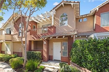 This beautifully maintained upper level carriage unit offers the privacy of no neighbors above or below and is located in the highly desirable Vineyard community. Designed with comfort and functionality in mind, the open concept layout is filled with natural light and features warm carpeting in the main living areas, neutral tones throughout, custom lighting, and a newer water heater. The spacious living room includes a cozy fireplace and opens to a private terrace, perfect for indoor and outdoor living, whether you're relaxing or entertaining. The bright and inviting kitchen features rich cabinetry, upgraded stainless steel appliances, generous counter space, and a seamless connection to the dining and living areas, ideal for gatherings and everyday living. The primary suite offers a peaceful retreat with an upgraded bathroom that includes modern fixtures, custom lighting, and a tub. A secondary bedroom and full guest bath provide comfort and flexibility for guests or a home office. Additional highlights include a one car attached garage with direct access, an assigned parking space, and access to the community pool and spa. Enjoy nearby shopping, dining, and entertainment at Foothill Ranch Towne Center, as well as close proximity to the Irvine Spectrum, Great Park, and scenic trails in Whiting Ranch and Limestone Canyon. With low HOA dues and no Mello-Roos, this home is a must-see.
