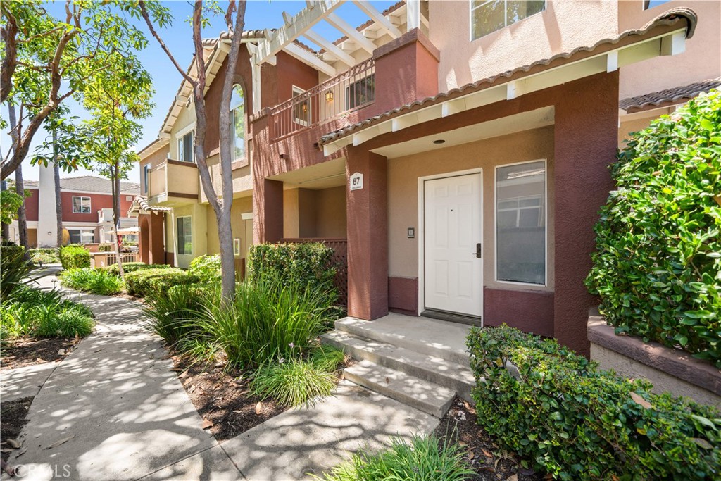 This beautifully maintained upper level carriage unit offers the privacy of no neighbors above or below and is located in the highly desirable Vineyard community. Designed with comfort and functionality in mind, the open concept layout is filled with natural light and features warm carpeting in the main living areas, neutral tones throughout, custom lighting, and a newer water heater. The spacious living room includes a cozy fireplace and opens to a private terrace, perfect for indoor and outdoor living, whether you're relaxing or entertaining. The bright and inviting kitchen features rich cabinetry, upgraded stainless steel appliances, generous counter space, and a seamless connection to the dining and living areas, ideal for gatherings and everyday living. The primary suite offers a peaceful retreat with an upgraded bathroom that includes modern fixtures, custom lighting, and a tub. A secondary bedroom and full guest bath provide comfort and flexibility for guests or a home office. Additional highlights include a one car attached garage with direct access, an assigned parking space, and access to the community pool and spa. Enjoy nearby shopping, dining, and entertainment at Foothill Ranch Towne Center, as well as close proximity to the Irvine Spectrum, Great Park, and scenic trails in Whiting Ranch and Limestone Canyon. With low HOA dues and no Mello-Roos, this home is a must-see.