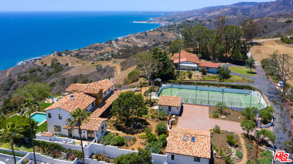Southwestern by the sea with 180 degree ocean views from the sunrise at Palos Verdes, to Catalina and the sunset towards Point Dume and Channel Islands. Designed by Marc Appleton, AIA. Surrounded by state parkland and hiking trails yet close to town, at the top Big Rock Drive in Malibu. Luxuriously equipped with a north/south facing lighted tennis court, private and heated pool and spa, fully fenced yard and gated driveway, wrap-around patio areas and lawn, covered porch off the dining area, and a peaceful indoor/outdoor flow from the main living areas to the front and rear yards and pool. The ocean view chef's kitchen seamlessly connects the family room and dining room, for joyous warmth and entertaining, an open floor-plan with high ceilings, plaster walls, tile flooring downstairs, and oak floors upstairs. There is a downstairs office and expansive ocean and mountain views from every room. The library and loft area connect to an intimate roof-top deck with a view of downtown Los Angeles city lights. Built to view the ocean and sky, the master bedroom has two open deck areas with spectacular coastline views, en-suite bath with an ocean view shower and tub.