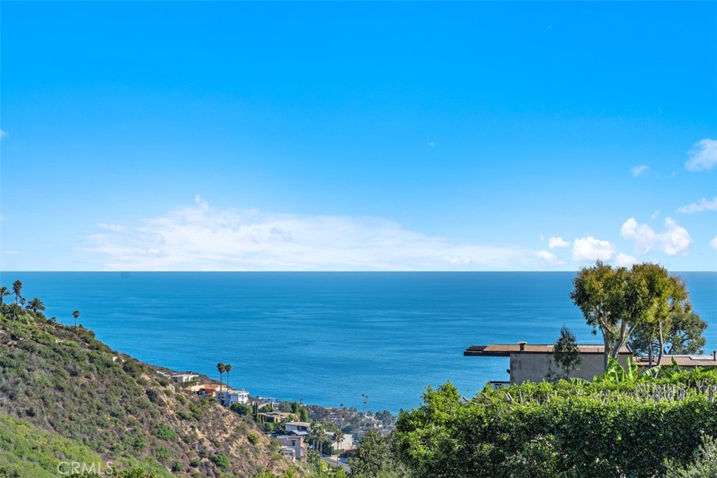 This charming single-story 2-bedroom, 2-bathroom home, spanning just under 1,100 sq. ft., offers an open layout that highlights spectacular panoramic views of the ocean, canyon, hills, and city lights. Peaceful and secluded, it sits on a quiet street with no streetlights and is bordered by wilderness behind and to one side, providing open space and exceptional privacy, creating a rare retreat in Laguna Beach.
Inside, the home features quartz kitchen counters, upgraded baths, and stainless steel appliances. The ocean-view great room seamlessly blends the kitchen, dining area, and living room with a cozy fireplace, while a spacious deck extends the living space outdoors, making indoor/outdoor living effortless and ideal for both relaxation and entertaining.
A true one-of-a-kind property, this home combines comfort, privacy, and breathtaking views, offering the perfect setting to enjoy the beauty and tranquility of coastal living.