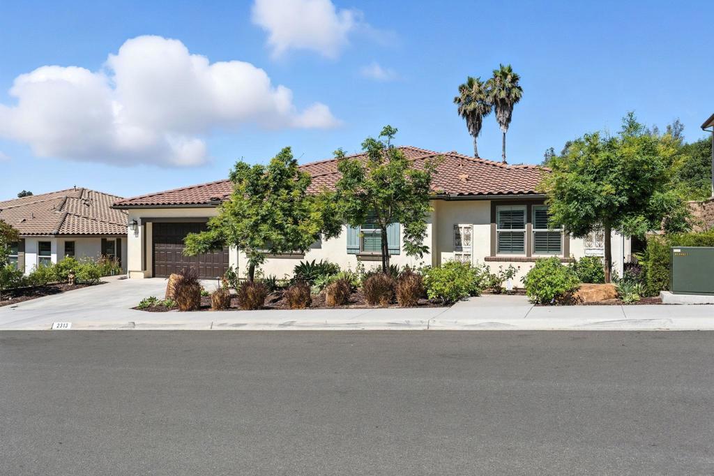 Welcome to where modern comfort meets California luxury in this immaculate single-story home, built in 2020 by Trumark Homes and nestled in the highly sought-after Groves at Edencrest community. Boasting 4 bedrooms, 3.5 bathrooms, and over 3,100 sqft of open-concept living, this home is the perfect blend of style, space, and function. Inside, luxury vinyl plank flooring flows throughout spacious living areas. The upgraded kitchen is a showstopper, featuring quartz countertops, stainless steel appliances, white shaker cabinets, and an oversized island ideal for gatherings. A large walk-in pantry adds both utility and convenience. Each bedroom offers generous space and storage, while the primary suite provides true retreat vibes with a spa-inspired bath and a huge walk-in closet. You'll also appreciate the well-equipped laundry room with extra cabinetry and workspace. Energy efficiency is integrated with fully paid-off solar, helping to reduce monthly costs all year round. Step outside and enjoy the ultimate entertainer’s backyard—complete with a large covered outdoor living area, dual TVs, a built-in BBQ island with bar seating, and a private Jacuzzi beneath a stylish pergola. Surrounded by tropical palms, custom hardscaping, and low-maintenance turf, this backyard is ready for everything from peaceful relaxation to lively weekend entertaining. This home checks all the boxes with modern finishes, thoughtful layout, energy efficiency, and a resort-style outdoor lifestyle—all within one of Escondido’s top newer communities.