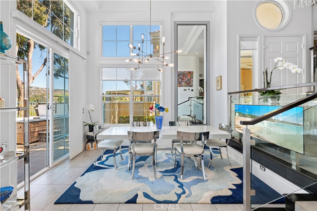 Located within the beautiful French-inspired gated community of Newport Ridge Vistas, this sophisticated town home has been completely reimagined from top to bottom offering luxury lifestyle and finishes like Italian porcelanosa marble, custom Restoration Hardware light fixtures and Sonos sound system inside and out. Fully furnished, as you enter the home you are greeted by soaring ceilings and a light filled dining room. The kitchen is a gourmet delight with 16 foot ceilings and views of the canyon featuring high gloss flat front cabinets with built-in Miele espresso machine, white marble counter tops and back splash, Subzero fridge, 2 dishwashers, a magnetic Miele cooktop and in wall ovens. The kitchen and dining area flow seamlessly to your private rear yard oasis with water feature, built-in BBQ and hot tub overlooking the tranquil canyon view. An office on the main level provides for the convenience of working from home. Take the stairs, with custom glass railing, to your primary retreat warmed by its own gas fireplace, a balcony to take in the canyon views and dual his/her closets. The spa-like primary bath features a soaking tub, walk-in shower and custom dual sink cabinetry with seated vanity area. Two secondary bedrooms and another full bathroom make this an eminently livable floor plan. Security cameras throughout, custom storage and laundry center round out this must-see property. Newport Ridge Vistas offers its own large green space and heated pool/spa as well as close-proximity to shopping, restaurants and Newport Coast Elementary School. All the amenities of Newport Ridge are nearby including pool and spa, sport courts, parks and playgrounds. *VIDEO TOUR AVAILABLE*