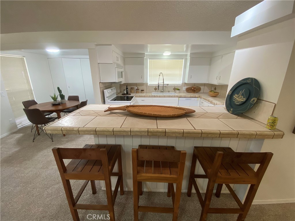 Remodeled unit in the resort like lifestyle of Country Club Terrace. Nice large covered patio great for entertaining. Beautiful grounds, Sparkling pool, nice open kitchen with breakfast bar which looks into the spacious living room with cozy fireplace for those cool winter nights. Separate dinning area. Condo is located very close to Hawk's Landing Golf Course. 1 car carport. Perfect for a live in or a vacation home. This property is in move in condition just waiting for its new owner.