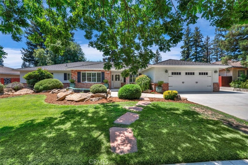 Welcome to this luxurious 3-bedroom, 2-bath retreat offering 2,789 sq ft of beautifully designed living space located in the acclaimed Clovis North School District. From the moment you step inside, you’ll appreciate the craftsmanship and high-end features throughout, from the striking wood beam ceiling and cozy gas fireplace in the great room to the elegant crown molding and custom finishes that define every space. The open-concept layout seamlessly connects the kitchen, casual dining area, and main living room, ideal for both everyday living and entertaining. The gourmet kitchen is a chef’s dream, showcasing Jenn-Air appliances, granite countertops, a farm-style sink, an induction cooktop, and custom cabinetry. A separate formal dining room offers a private space for special occasions or dinner parties. The flexible floor plan also includes a second living area that can easily be converted into a fourth bedroom, home office, or hobby room to suit your needs. The luxurious primary suite features a spa-inspired bath with a custom jetted tub and rising wall for easy entry, granite counters, a heated fan, and a beautifully etched glass shower. The second bathroom also features custom etched glass and upscale finishes. Additional highlights include custom closets, ample storage throughout, and a spacious laundry room with hookups for both gas and electric dryers. Step outside into your own backyard paradise featuring a resort-style pool with a rock waterfall, lush landscaping, and a covered patio perfect for entertaining. A generously sized side yard offers room for additional parking or trailer storage. Pet owners will also appreciate the enclosed dog run with interior access, thoughtfully designed to keep pets secure while preserving the beauty of the front and back yards. With its blend of elegance, functionality, and resort-style amenities in a top-rated school district, this home is truly one of a kind. Don’t miss your opportunity to make it yours!