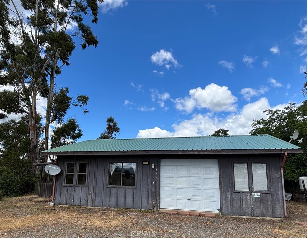 Tucked into the hills above Lakeport, this 13-acre Pear View Estates property offers privacy, views, and multi-use potential. Located in a small gated community just 10 minutes from the town of Lakeport, it feels remote yet accessible. Originally designed for expansion, it includes two building pads: one with a small 1-bedroom residence and another ideal for a future main home. A second septic system, noted in a prior listing, enhances future development options. Two separate driveways—one to the house and one to the shop—make it suitable for extended families, live/work setups, or rental use. The home has a bathroom, metal roof, and interior improvements already underway - garage was in the process of being converted - ready for the next owner to continue the vision. On-grid power serves both the home and the shop, where plumbing was started for a future bathroom. Water is provided by a well and two springs, stored in four tanks for household and garden use. Located in a rare micro-area where surrounding parcels enjoy their own lakes, the property has also received annual income from PG&E for seasonal staging on the flat land by the gate, per the owner and paperwork. With infrastructure in place and room to grow, this is a versatile opportunity in a peaceful, scenic setting.