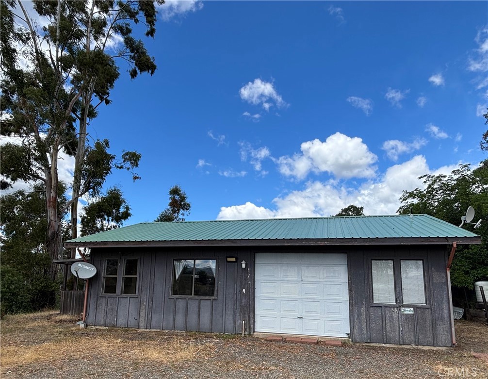 Tucked into the hills above Lakeport, this 13-acre Pear View Estates property offers privacy, views, and multi-use potential. Located in a small gated community just 10 minutes from the town of Lakeport, it feels remote yet accessible. Originally designed for expansion, it includes two building pads: one with a small 1-bedroom residence and another ideal for a future main home. A second septic system, noted in a prior listing, enhances future development options. Two separate driveways—one to the house and one to the shop—make it suitable for extended families, live/work setups, or rental use. The home has a bathroom, metal roof, and interior improvements already underway - garage was in the process of being converted - ready for the next owner to continue the vision. On-grid power serves both the home and the shop, where plumbing was started for a future bathroom. Water is provided by a well and two springs, stored in four tanks for household and garden use. Located in a rare micro-area where surrounding parcels enjoy their own lakes, the property has also received annual income from PG&E for seasonal staging on the flat land by the gate, per the owner and paperwork. With infrastructure in place and room to grow, this is a versatile opportunity in a peaceful, scenic setting.