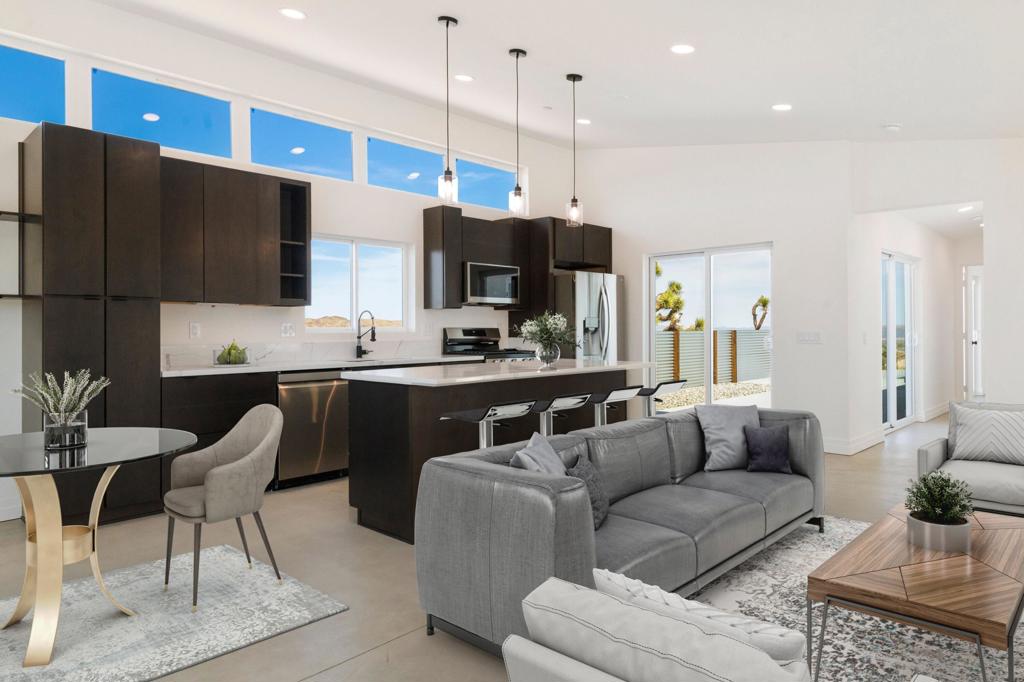 Experience elevated desert living in this stunning New Construction home perched on a premier 18,500 sq ft hillside lot, where sweeping mountain views unfold from every room. Designed with style and serenity in mind, this modern retreat features a private 20 x10 PebbleTec pool with high-end Pentair equipment, thoughtfully positioned to maximize the breathtaking vistas. Surrounded by sleek metal perimeter fencing, the outdoor space offers the perfect blend of privacy, relaxation, and effortless entertaining.Inside, the open-concept layout is both sophisticated and inviting, anchored by a designer kitchen with rich dark wood cabinetry, quartz countertops, a spacious island, LG appliances, and sleek pendant lighting. Soaring ceilings and clerestory windows flood the interiors with natural light, creating a seamless connection to the desert landscape. The guest bath boasts an oversized soaking tub, while the spa-inspired primary suite features a walk-in shower wrapped in floor-to-ceiling large-format tile. Additional highlights include three Mitsubishi mini-splits for efficient climate control, EV & Solar ready pre-plumbing, gas and electric washer/dryer hookups, an extended driveway with garage potential, and paved road access. Ideally located just 10 minutes from Joshua Tree National Park and moments from downtown's shops and dining, this thoughtfully curated retreat is the ultimate fusion of design and desert magic.