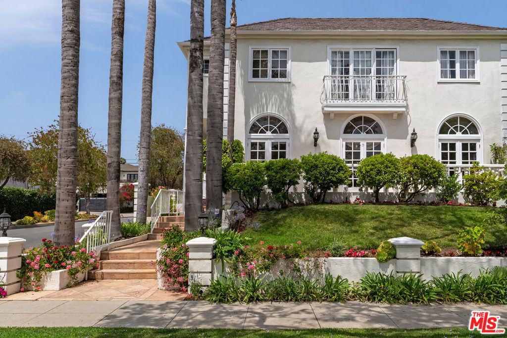 Located on iconic Palm Drive, this stately, custom-built residence captures the essence of Beverly Hills living. Set on a prized corner, the home is bathed in natural light and framed by soaring palm trees that define the neighborhood's timeless elegance. A grand front balcony offers views over the tree-lined street. While inside, exceptional ceiling heights create a sense of volume and grandeur throughout. The layout is ideal for entertaining, featuring a dramatic ballroom, expansive living areas, and a dedicated office on the main level. The primary suite faces the street and includes a sliding door for indoor-outdoor flow, along with dual walk-in closets. All bedrooms offer generous closet space, and there is ample built-in storage thoughtfully placed throughout the home. The kitchen and bedrooms are generously proportioned, offering the rare combination of size and scale in this location. An elevator serves all floors, including a bright and versatile lower level with two bedrooms, its own entrance that doubles as a service entrance, large living room, and private sauna. The lower level works perfectly for guests, wellness, or long-term stays. The backyard features both hardscaping and grassy areas, ideal for entertaining and relaxation. A truly rare offering with space, elegance, and location all in one. Square footage is an approximation; buyer to conduct their own investigations. Public records reflect 4,522 SF for first and second floors.