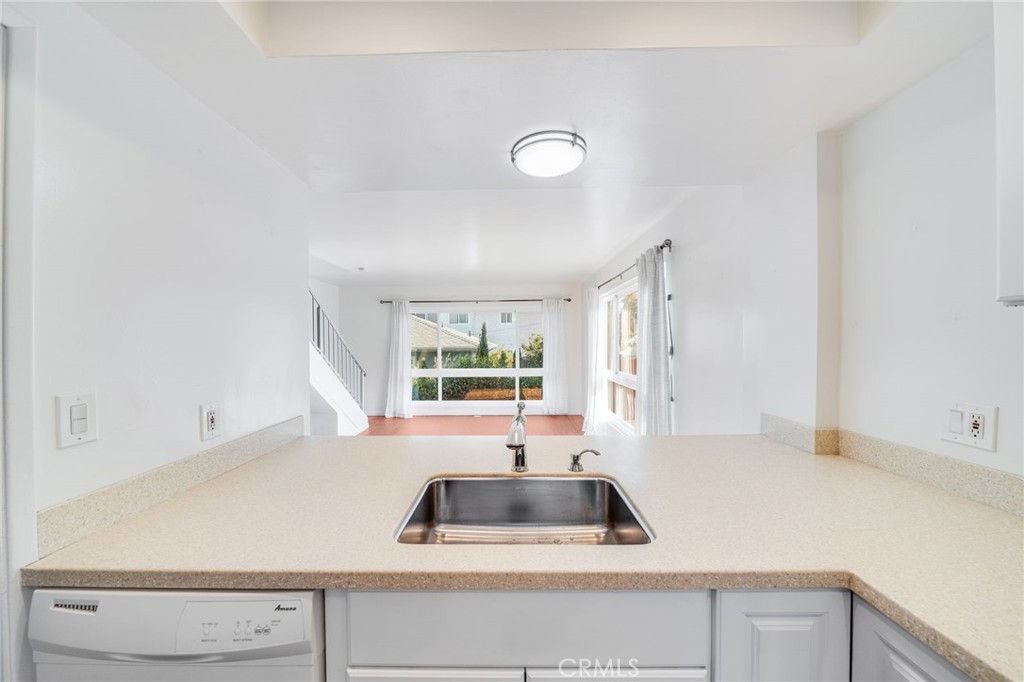 Moments from Del Prado Avenue's cafes, shopping and restaurants, this 2 Bed/1.5 Bath town-home style end unit gets great natural light and even has an Ocean/Coastline view from the upstairs bedroom. No one living above or beneath, both bedrooms are upstairs while the kitchen, living and powder rooms are downstairs. Enjoy wood-like vinyl flooring downstairs and carpeted bedrooms. Includes refrigerator, dishwasher, microwave, oven & shared washer and dryer (non coin op). 1-car garage and a shared deck & patio. Peaceful rock garden out back. Sorry NO pets.