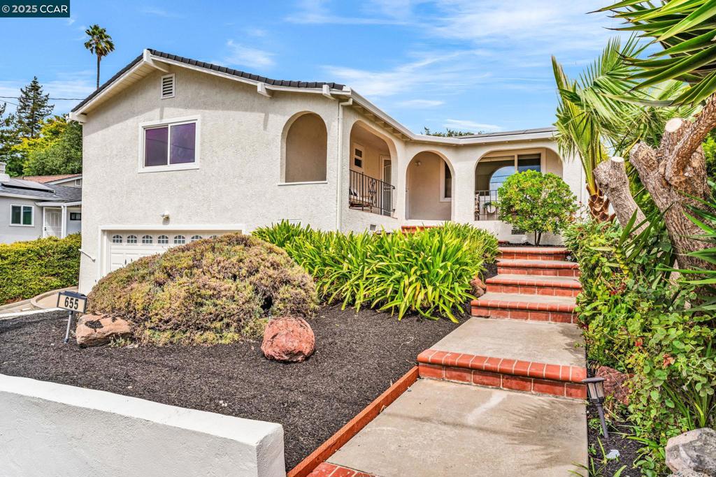 Welcome to this beautifully updated Mediterranean-style bungalow perfectly perched to enjoy sweeping views of the Bay and stunning sunsets. Thoughtfully designed with both comfort and style, this home offers bright open spaces, modern upgrades, and timeless character. Spacious foyer and living area with vaulted ceilings, gleaming hardwood floors, and a cozy fireplace. Generously sized kitchen with vaulted ceilings, stainless steel appliances, pantry, abundant cabinetry, and room for a large dining tablle. Do the dishes all while overlooking bay views. Separate Family Room – Saltillo tile flooring and sliding glass doors lead seamlessly to the private backyard patio—perfect for entertaining. The primary suite – Features a walk-in closet, sliding barn door, and updated ensuite with large glass-enclosed shower. Two additional bedrooms with crown molding, ceiling fans, recessed lighting, and a modern bathroom with slate tile floors, tub/shower combo, and stone-top vanity. Covered front porch with tile flooring ideal for sitting and watching the sunset views. Low-maintenance private backyard with patio. Solar panels for energy efficiency and Tesla EV charger included.