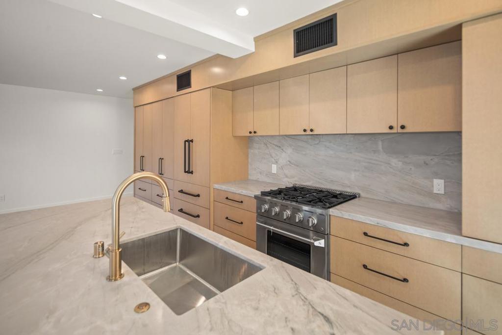 Remodel just completed - Everything in this custom designed unit will steal your heart! From the beautiful and artful refinished cement floors, all-new kitchen, tiled bathrooms, stainless appliances and built-out closet, one look and you'll be sold! Large 2 bedrooms / 2 full baths situated a (very!) short walk to town, beaches and schools, this sleekly contemporary condo is move-in ready! Highlights: **Kitchen: New stainless appliances, dreamy cabinets, exquisite hard surface countertops and island for gathering friends and family. **Living & dining area: Fireplace in great room, dining area features exquisite real wood paneled wall, floating shelve, built-in buffet and wine fridge. Both dining and living areas open out to indoor / outdoor living space. **Private outdoor patio for enjoying Coronado's year-round perfect climate! **Upscale finishes include very cool cement flooring throughout (must see to appreciate the beauty and color variations), paneled feature walls in dining area and primary bedroom, fully built-out custom closest in both bedrooms. **Bathrooms are spacious and beautifully designed with wall-to-ceiling tiled showers and custom vanities. **Full size washer and dryer in unit. **Secure parking in community garage. **Small and quiet private condominium building. Come tour this rare gem, it won't last!