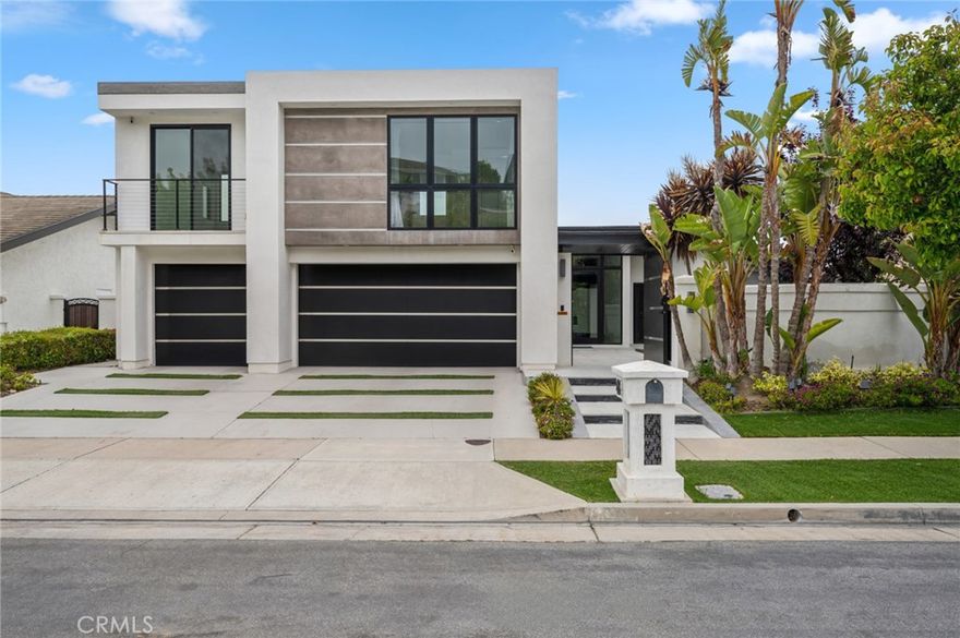 Welcome to 48 Drakes Bay—a striking blend of coastal sophistication and modern design, ideally positioned in the heart of Corona del Mar. Spanning approximately 3,850 square feet, this thoughtfully designed residence offers a rare combination of volume, functionality, and refined elegance just moments from the village, award-winning schools, world-class shopping, and pristine beaches. Perched to capture serene city light views, this five-bedroom, four-and-a-half-bathroom home features a highly versatile layout with three bedrooms on the lower level and two on the upper level—perfect for accommodating multi-generational living, guests, or a private office setup. Expansive bi-folding doors along the rear facade create a seamless indoor-outdoor connection, opening to a tranquil patio and allowing natural light to pour into the living spaces. The chef’s kitchen is a true centerpiece, boasting high-gloss white lacquer cabinetry, premium stainless steel appliances, and an oversized island with a custom built-in breakfast nook—ideal for casual dining or gathering with friends and family. Every detail has been thoughtfully curated to support both everyday living and effortless entertaining. Additional highlights include a wide, finished three-car garage with extensive built-in storage, a spacious primary suite retreat, and a location that puts you just minutes from Fashion Island, top-rated restaurants, and the best of Orange County coastal living.