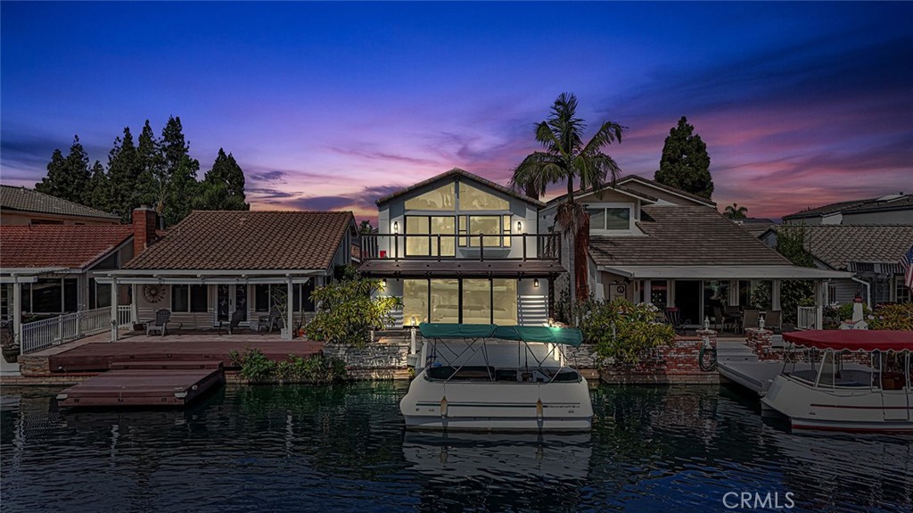 Experience the Best of Waterfront Living on the Keys! Where timeless Spanish-inspired architecture meets stylish, contemporary design. From the moment you step through the private gated entry and double front doors, you’ll feel the unique charm this lakefront home offers. The open-concept layout features White Oak flooring throughout, seamlessly connecting the spacious living areas with stunning lake views as your backdrop. The thoughtfully designed kitchen opens to the main living and dining spaces, creating a perfect environment for hosting and entertaining. Expansive pocket doors off the living room lead to your own backyard retreat, complete with private boat dock and canal and main channel views—positioned for privacy with no direct neighbor across the water. Downstairs, you'll find a versatile bedroom and full bath ideal for guests, as well as a separate laundry room for added convenience. A striking floating staircase takes you to the second level, where floor-to-ceiling windows bathe the home in natural light. Upstairs, a spacious loft offers flexible use—perfect as a media room, office, or play area. The generous primary suite is a true sanctuary, featuring a cozy fireplace, a wall of windows overlooking the lake, and a private balcony to enjoy peaceful sunset views. The spa-like en-suite bath boasts a walk-in shower, standalone soaking tub, and an oversized walk-in closet with skylight. Two additional bedrooms and a full bathroom complete the upper level. This is your opportunity to own a slice of lakefront luxury in Lake Forest’s highly sought-after Keys community.