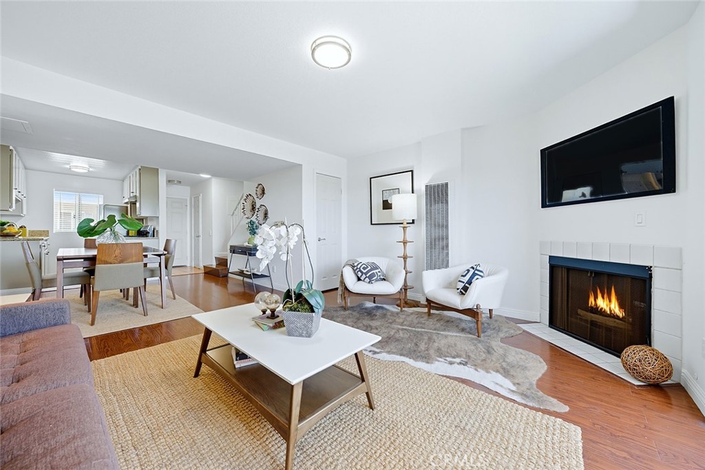 An exceptional and stylish living experience awaits at Loma Garden Villas. This top-floor, townhome-style condo delivers the space and feel of a private residence across two well-designed levels. Step inside to a bright living room anchored by a cozy fireplace, flowing into a tasteful kitchen with granite countertops and a convenient powder room on the main level, ideal for everyday ease and casual entertaining. Upstairs, you’ll find two bedrooms and two full bathrooms, including a flexible suite with its own private entrance, perfect as a guest retreat, home office, or creative studio. Thoughtful updates include hardwood floors and modern finishes throughout. Enjoy morning coffee or evening breezes on your private balcony, plus two tandem parking spaces in a gated garage. The building offers secure entry, an inviting lobby, elevator, and a third-floor common laundry room. All of this just minutes from Cal State Long Beach, Long Beach City College, parks, shopping, restaurants, and the beach, placing you at the heart of convenience and coastal energy. Stylish, move-in ready, and uniquely laid out, this is Long Beach living, elevated.
