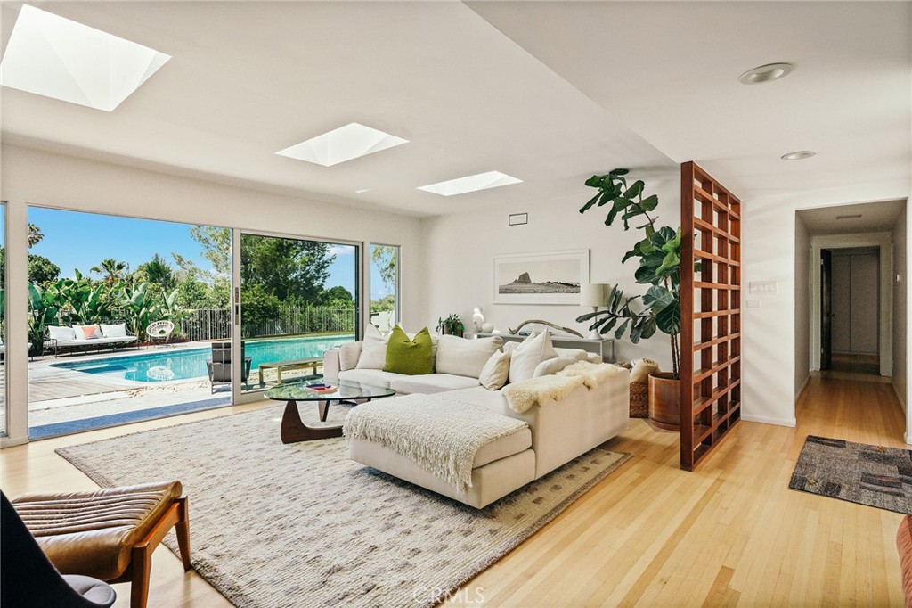 Welcome to 34 Shady Vista—a beautifully reimagined one-level, mid-century modern ranch-style home nestled on a sprawling 30,116 SF lot in the heart of Rolling Hills Estates. Originally designed by acclaimed architect Henry J. Friel, AIA, this 4-bedroom, 3-bathroom residence seamlessly blends timeless design with thoughtful modern updates, offering 2,201 square feet of comfortable and refined living. Situated on a peaceful cul-de-sac with captivating canyon and city light views, this home has been meticulously upgraded to preserve its architectural integrity while enhancing everyday living. Step inside to discover refinished hardwood flooring, brand-new custom sliding glass doors and windows that flood the space with natural light, and a completely remodeled kitchen featuring custom cabinetry, Thermador appliances, new flooring, designer lighting, and Rejuvenation hardware. The family room is highlighted by new skylights and this bright room overlooks the private backyard. The backyard is an entertainer’s dream: a fully renovated pool with new hardscape, landscaping, outdoor shower, plaster, baja shelf, and in-ground spa. All of these amenities and striking views of Mt Baldy and the San Gabriel mountains. This is California living at its finest—architecturally significant, masterfully upgraded, and perfectly located.