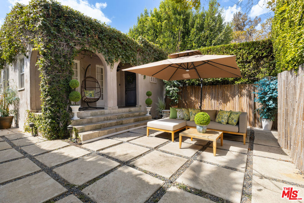 Tucked away on a picturesque tree-lined street, this private and stylish retreat embodies the elegance of Old Hollywood Regency design with modern upgrades throughout. Fully furnished inside and out, with curated furniture pieces and elegant artwork, the property is move-in ready and perfect as a chic pied-a-terre. The property features 2 beds and 2 baths with its own private front and back yards, mature hedging, and gated entry for ultimate security and seclusion. The interiors are filled with natural light and highlighted by vintage wood floors, spacious closets, and an upgraded chef's kitchens with stainless steel appliances and pantry. In-unit washer/dryer and central A/C add to the convenience. Located just moments from The Grove, Farmers Market, Beverly Center, and the vibrant Third Street corridor, where beloved spots like Joan's, Oste, Izaka-Ya, Little Door, and El Carmen await.