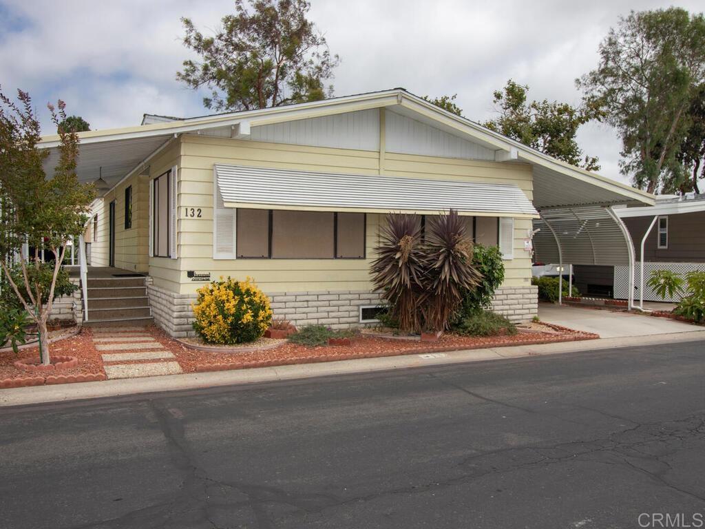 Nestled in the highly desirable Laguna Vista 55+ gated community in Oceanside’s scenic San Luis Rey area, this charming, manufactured home with lake views offers the perfect balance of comfort and coastal living. Built in 1981, the home features 1,536 sq. ft. of thoughtfully designed single-level living with two bedrooms and two full baths. The open floor plan feels bright and spacious, highlighted by vaulted ceilings in the living room and plantation shutters in the bedrooms that welcome natural light and refreshing ocean breezes. The generous living areas are ideal for both everyday relaxation and entertaining guests. Step outside to the private 10x10 patio slab at the rear of the home and enjoy serene views of the lake and fountain. Additional features include two storage sheds, curved awning poles to maximize carport parking, and a newer roof installed in 2022. Laguna Vista offers beautifully landscaped grounds with tranquil lakes, fountains, and a wide array of resort-style amenities including a community pool, spa, ballroom, shuffleboard, horseshoes, pool tables, reading library, and pickleball/tennis courts. Conveniently located just minutes from beaches, shopping, and dining, this home is a wonderful opportunity to enjoy the best of North County coastal living. Some photos have been virtually staged.