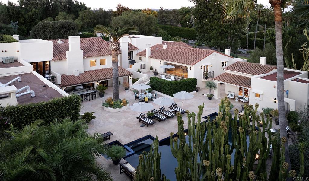 Quintessential Southern California  Nestled within the prestigious enclave of the Rancho Santa Fe Covenant, 6977 Las Colinas stands as a timeless homage to early California hacienda architecture. Inspired by the grace of 1920s Montecito, this three-acre estate embodies the serenity and mission-style beauty that define Southern California’s heritage. Native palms, olive and lemon trees, lavender, and white roses create a landscape as natural as it is refined.  Behind a hand-forged 18th-century Mexican door, warmth and authenticity unfold. A beamed portico with a fireplace opens to a courtyard alive with greenery, a vintage fountain, and softly glowing lanterns. Inside, reclaimed wood floors, carved beams, plaster archways, and antique Mexican doors connect luminous rooms and sun-drenched terraces.  Recently restored, the home balances heritage with modern livability. Remodeled baths, updated systems, and the careful restoration of original ironwork and finishes honor its “Old Soul” while revealing a “Young Heart.” The interiors evoke the relaxed refinement of a boutique hotel—elegant yet unpretentious, where every detail feels intentional.  Expansive terraces, a heated pool and spa, an outdoor kitchen, and a sport court celebrate the indoor-outdoor lifestyle. Set along a tree-lined Covenant road, this private retreat is minutes from the Village and the historic Inn at Rancho Santa Fe. Covenant ownership includes immediate membership eligibility to the Rancho Santa Fe Golf & Tennis Club—no waitlist or sponsorship required.