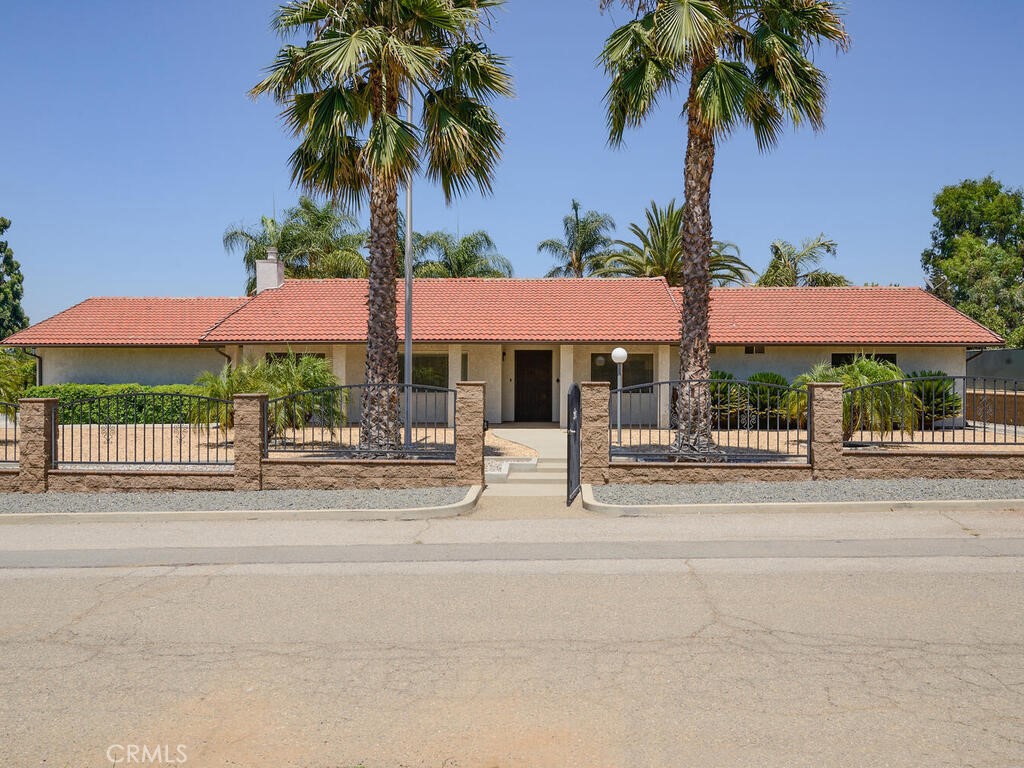 Attention car collectors, mechanics, DIY'ers and hobbyists, your dream home awaits! This beautiful single story ranch style home features 4 roomy bedrooms, 2.5 baths, a den with a fireplace, indoor laundry, central air and heat, tile roof, and an attached, finished 3 car garage with 200 amp service. As nice as this home is, you'll love the two large workshops that come with this home. The first a 1500 sq foot (measures 30' x 50') steel building with two - 10 foot tall roll up electric doors and a finished office area. The second is a 1440 sq ft (measures 24' x 60') stucco building that is fully finished inside and features two 10-foot-tall automatic roll up doors. This stunning property has inside parking for up to 19 cars! In addition, there are 2 covered RV parking stalls and additional uncovered RV parking. Zoned A1, the opportunities are limitless!
This fine property is located in the west end of Riverside near La Sierra and Victoria, on a quiet private cul de sac street with only 4 homes. There is nearly an acre of land that is fully fenced and has an electric access gate that leads to the large concrete driveway. There are 2 flagpoles, outdoor lighting, and the low maintenance landscaping has mature Palm trees with sprinklers and drips. Nestled in a peaceful neighborhood, adjacent to Victoria Avenue walking trails, and close to top rated schools, Metrolink, shopping and dining. Also commuter close to the 91 freeway. Shown by appointment only, plan your visit today!