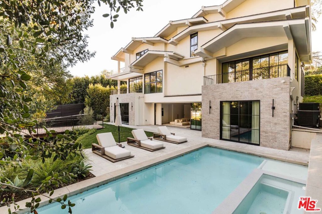 This newer construction home blends curated, designer-done details with luxury amenities on one of Brentwood's most coveted and private streets. The formal living room is a showpiece, featuring cross-beamed high ceilings, towering black metal picture windows, and a striking double-sided fireplace shared with the formal dining room. The custom-designed chef's kitchen boasts Miele appliances and an expansive center island with counter seating, seamlessly flowing into an open-concept family room bathed in natural light. The upper level offers three bedrooms including the oversized primary suite with a private balcony, an open shower and tub area, a double vanity, and a custom walk-in closet. Two additional ensuite bedrooms and a spacious laundry room complete the upper level. Enjoy views of mature trees and verdant landscaping from nearly every room. The lower level is an entertainer's dream, with a stunning built-in bar, a large ensuite bedroom, state-of-the-art gym with an en-suite bath, and an adjacent bonus/playroom area. This level opens up to the recently upgraded backyard, featuring a pool, spa, and expansive yard spaces, including one accessed via a private bridge over the creek to a firepit lounge. All this, just blocks from Brentwood Village, minutes to the beach, and situated in one of Los Angeles' most sought-after neighborhoods. Owners have made substantial improvements and upgrades since purchasing. Home may be sold furnished.