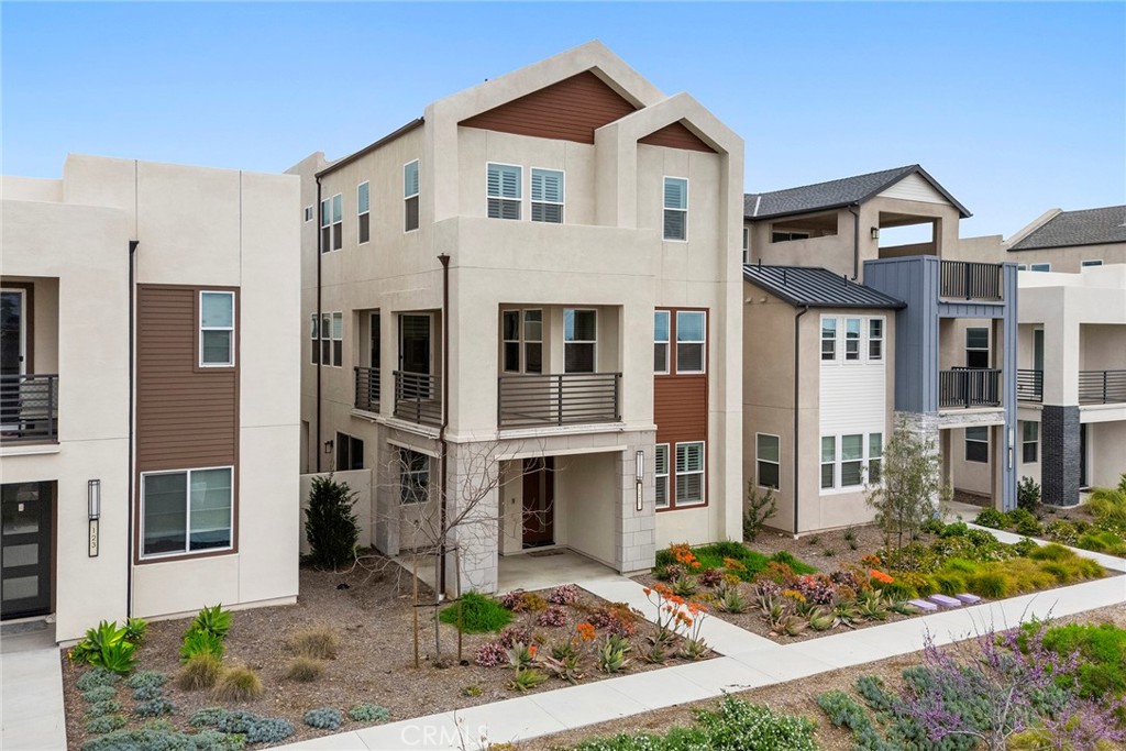 Welcome to this stunning 4-bedroom, 3.5-bathroom completely detached tri-level home located in the highly sought-after Solis Park neighborhood of Great Park. Built in 2022 and move-in ready, this modern residence offers thoughtfully designed living across three spacious levels with luxury vinyl plank flooring throughout. The first floor features a bonus living room, a private bedroom and full bathroom—perfect for guests or multigenerational living—along with access to a private side yard and a direct access two-car garage. The second level boasts an expansive open-concept layout with a family room, dining area, gourmet kitchen, powder room, laundry room, and an outdoor balcony ideal for relaxing or entertaining. Upstairs on the third level, you'll find a versatile loft, a luxurious primary suite with dual vanities, a large walk-in shower, and walk-in closet, along with two additional bedrooms and a hallway bathroom. The home also includes paid-off solar panels, offering energy efficiency and long-term savings. Elevated on a platform for enhanced views and complete with a mix of automatic shades, plantation shutters, and custom window treatments, this home is just minutes from the community pool, green spaces, and top-rated Solis Park School (K-8) and Portola High School (9-12).
