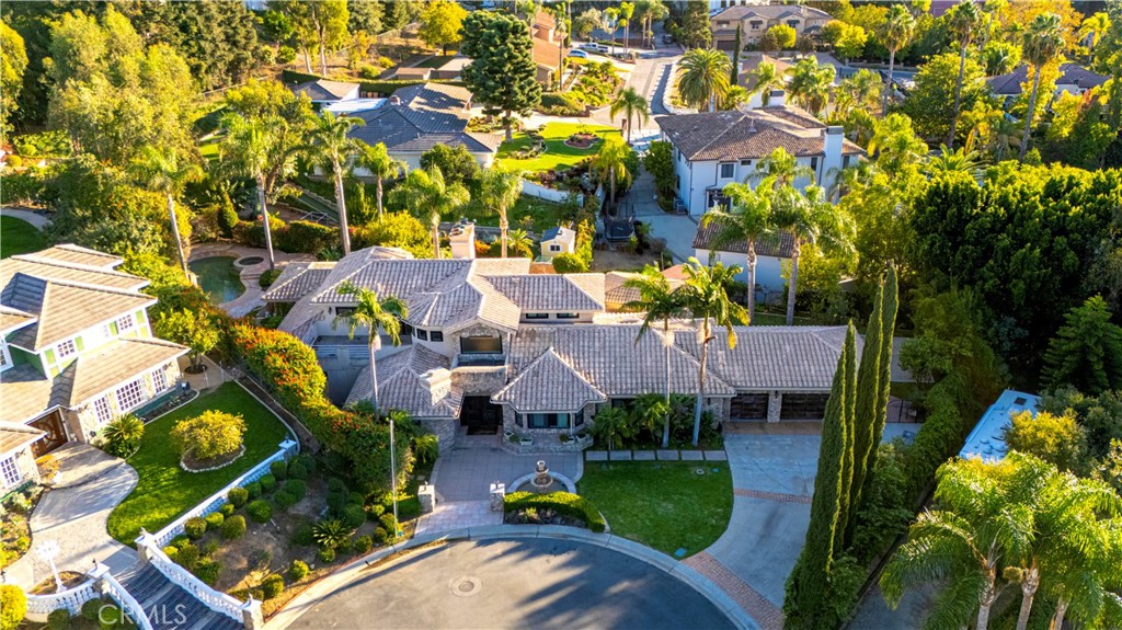 Exquisite custom estate in the prestigious gated community of Almeria, Anaheim Hills. Welcome to your dream home in one of Anaheim Hills’ most exclusive enclaves. Perfectly situated at the end of a private cul-de-sac, this custom-designed estate offers the pinnacle of refined living with approximately 5,574 sq ft of elegant interior space on a sprawling one-acre flat lot. Boasting five bedrooms + Office & 4.5 baths, this home has been meticulously remodeled with the highest attention to detail, quality, & craftsmanship. Step through the grand double-door entry into a light-filled foyer with a skylight, leading to a formal living room & dining room, both tastefully appointed for elevated entertaining. The living room showcases soaring cathedral ceilings with custom wood beams, while the dining room is adorned with 2 chandeliers, cozy fireplace & elegant architectural details. Upstairs, the primary suite is a private retreat with a fireplace, French doors to a balcony, & an adjoining room ideal as a nursery, office, or sitting area. The spa-inspired primary bath features a walk-in shower & closet, soaking tub, dual vanities & luxury finishes. A whole-house fan enhances energy efficiency & comfort. Main floor, three guest bedrooms include 1 en suite & 2 with a Jack-and-Jill bath. The family room features coffered ceilings, built-ins, a fireplace, & a temperature-controlled wine cellar. The chef’s kitchen includes Sub-Zero appliances, double ovens, six-burner range, espresso machine, 2 dishwashers, a farmhouse sink, oversized island, & abundant cabinetry. A sunny breakfast nook opens to a game room or executive office with a stone accent wall, wet bar, & a second ice machine. A large laundry room & 3/4 guest bath offer easy access to the resort-style backyard. Outdoors, enjoy mature fruit trees, a custom pool & spa with safety gate, a built-in BBQ island with ample seating under a covered patio & multiple entertaining spaces. Additional features: 3-car garage with storage, tankless water heater, filtration system, 2 beautiful fountains, integrated audio, video, internet, speakers all available throughout the home via centralized Control4 home automation system, dual newer HVAC systems, energy-efficient windows, $18K permitted electrical upgrade & newer carpet in the downstairs bedrooms. Ideally located near the 91 freeway, award-winning schools, shopping, dining & scenic trails—this home offers the perfect blend of luxury, privacy & convenience.