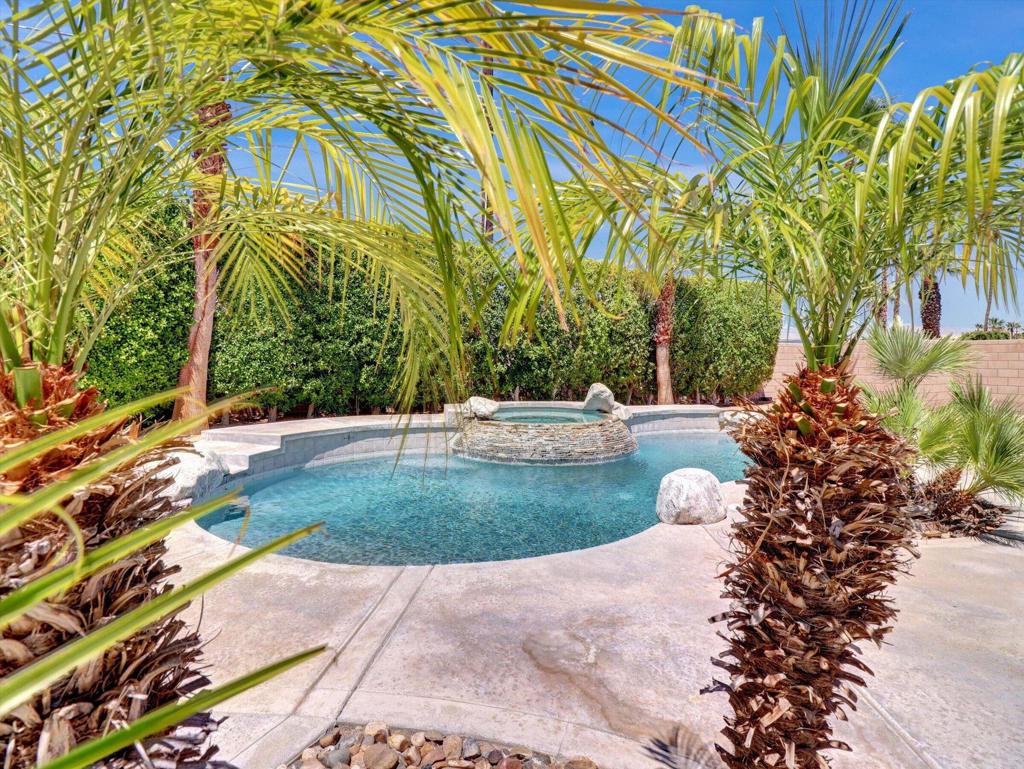 Tropical Resort, Private back yard with custom pool and spa in a tropical setting. Slate waterfall surrounded with palm trees mature landscaping, RV parking w/ gate and a Block wall for extra privacy.. Open concept 3 large bedrooms 2 upgraded bathrooms and a renovated kitchen. Solar system is paid off to ensure low utility bills. Leave the big city behind, Buy here in the Desert where your money buys you more house for your dollar. Large corner location.