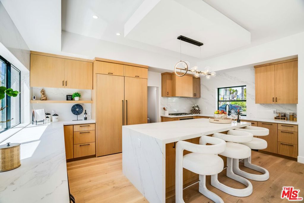 Discover a brand-new, reimagined home in the prestigious Comstock Hills area of Westwood. Experience the ultimate in convenience, just steps away from the amazing Westfield Shopping Center, the future Metro station, and all that vibrant Century City has to offer. This unique residence has been meticulously reimagined for modern living. The heart of the home is the gorgeous, spacious kitchen, which opens seamlessly to the greatroom, showcasing the ultimate in West Coast indoor/outdoor living. The versatile floor plan offers two bedrooms and 1.5 baths downstairs, along with two bedrooms and 2.5 baths upstairs. Connected to the primary bedroom is a versatile office space with endless possibilities: a nursery, gym, or even an amazing walk-in closet/glam room. A standout feature is the attached ADU (Accessory Dwelling Unit), complete with a bed, bath, kitchen, and laundry. It offers direct access from the home as well as its own private entrance, making it perfect for guests, extended family, or a rental opportunity. You'll love entertaining on the expansive rooftop deck, which features its own outdoor powder room and spectacular views of the Century City skyline. This is a rare opportunity to own a home that perfectly blends gorgeous, modern living with an unbeatable location.