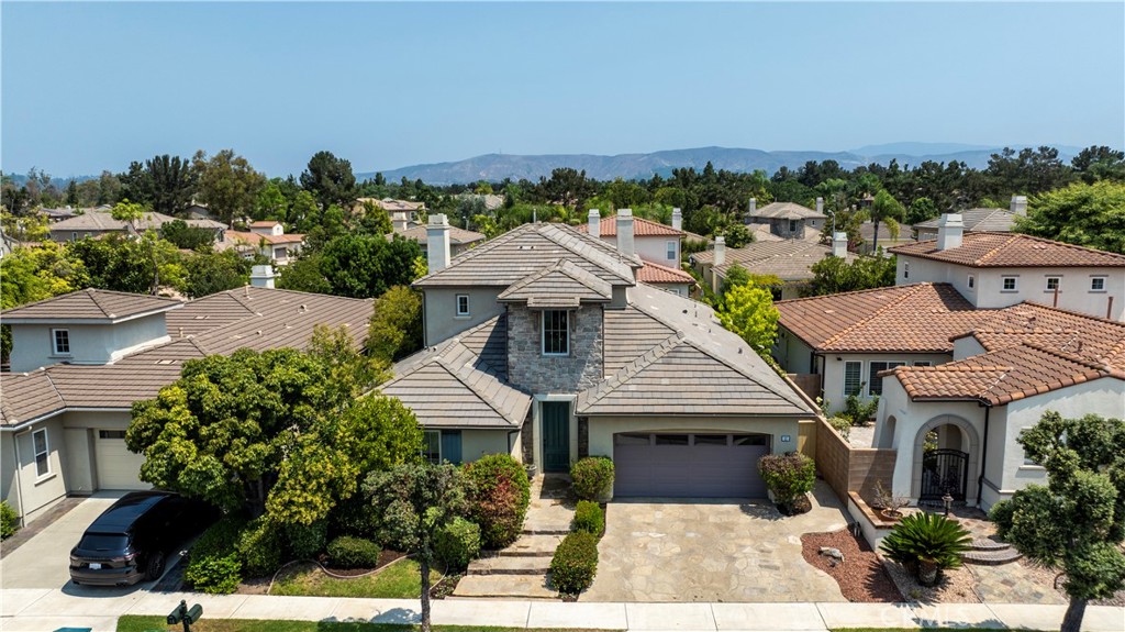 Set in the prestigious community of Triana, the gated enclave Bella Rosa at Northpark in Irvine offers this stunning home at 11 Flora Springs. This property blends luxury, comfort, and versatility. Soaring two-story ceilings, abundant natural light, and an open, flowing layout make it perfect for both everyday living and entertaining. The gourmet kitchen features rich cabinetry, elegant granite countertops, a large center island, breakfast nook, built-in desk, and stainless steel appliances—seamlessly connecting to the family room with an inviting fireplace, creating an exceptionally spacious great room. 11 Flora Springs offers multiple inviting gathering spaces. Freshly painted and newly carpeted, the home also boasts timeless travertine floors, giving it a move-in-ready feel.The main level lives like a single story, with three bedrooms, including the luxurious primary suite featuring direct backyard access, a spa-like bath, and an oversized customized walk-in closet. This home is ideal for MULTI-GENERATIONAL LIVING. Upstairs, a large bonus room and private bedroom suite with full bath offer endless flexibility as a teen hangout, home office, or workout space. The private backyard retreat showcases a built-in BBQ, timeless stonework, and mature landscaping. Nearby resort-style amenities include a pool, spa, gym, BBQ, parks, and sports courts. Not to be missed are the trifecta of top-rated schools—Hicks Canyon Elementary, Orchard Hills Middle School, and award-winning Beckman High School. Conveniently close to shopping, dining, golf, walking trails, and all major freeways and toll roads, this home is a rare combination of layout, neighborhood, and location—a rare find!