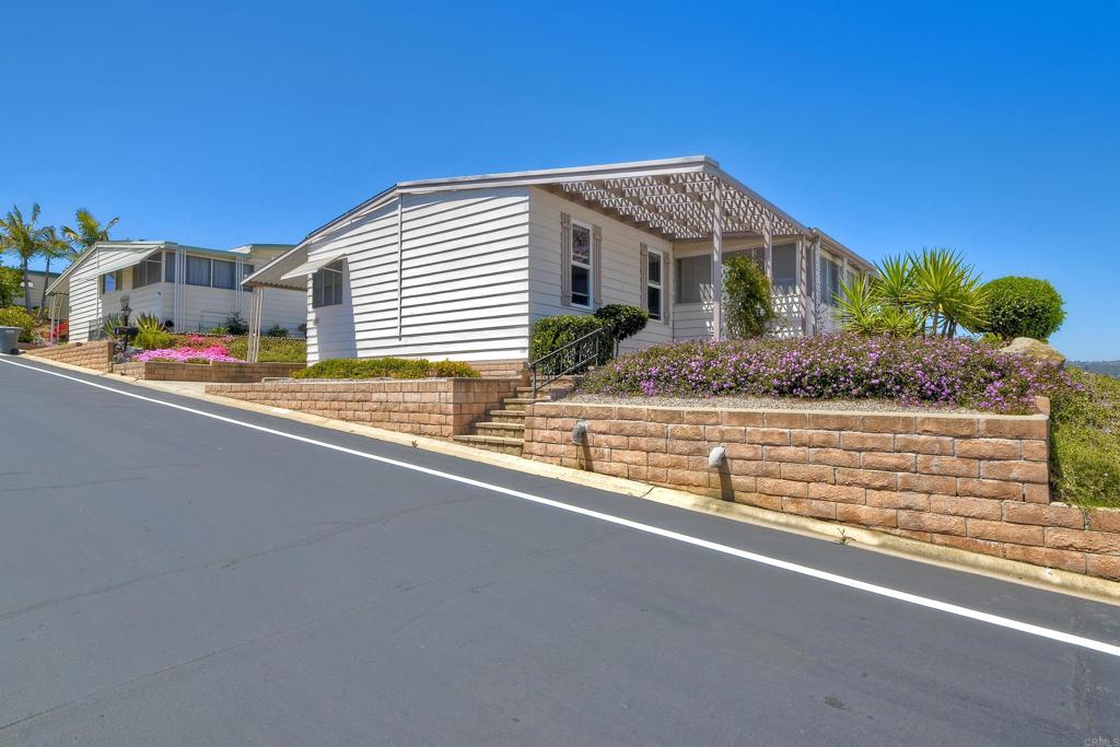 Nestled high on the hill this fantastic home has great views of the mountains in the distance. Light and bright inside, the layout is spacious with a bonus attached room with lots of windows, offering a nice breeze and great location in the park. New carpet and a roof that is 3 years young. La Moree Estates is a 55 plus community where residents own the land. The HOA fee includes a community pool, clubhouse, RV parking (if available), water, trash, sewer and cable. Conveniently located to shopping, 78 freeway, Palomar and Kaiser hospitals.