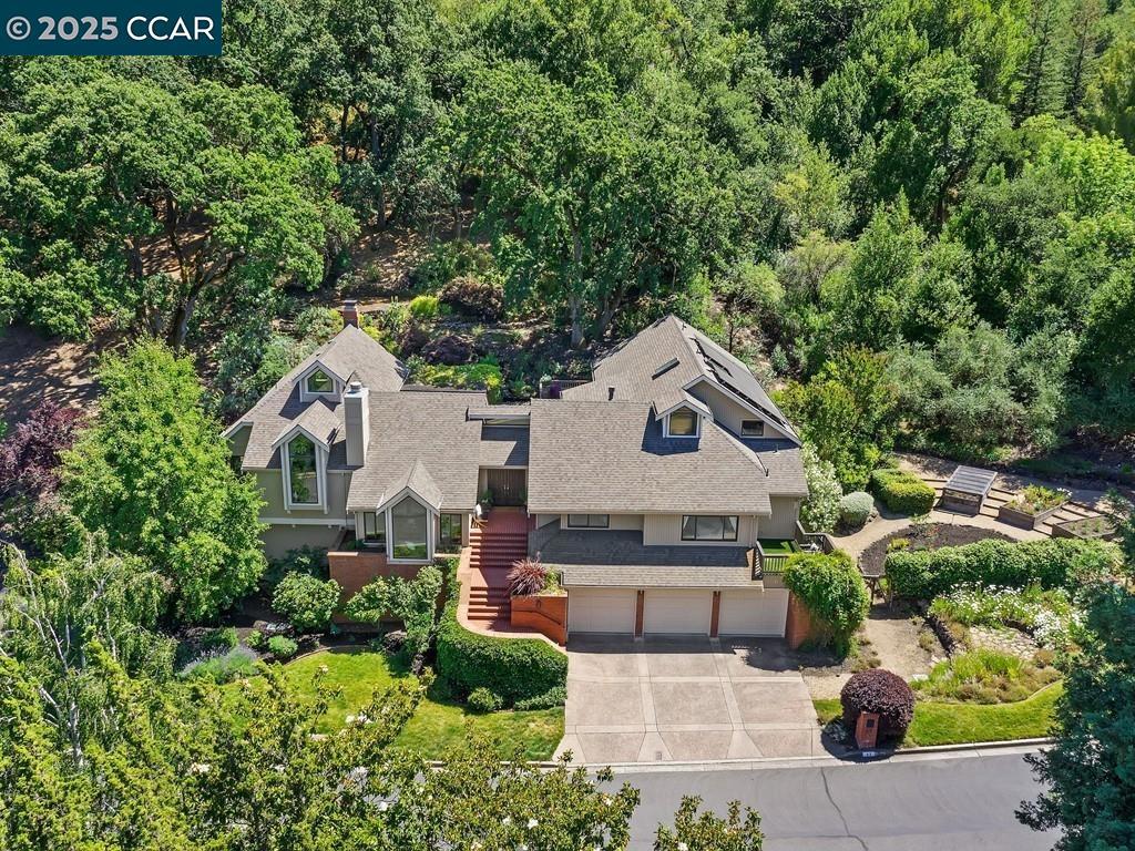 Tucked away on a quiet cul-de-sac in Lafayette’s coveted Happy Valley, this home offers the privacy of a 1.5-acre retreat with the convenience of being just a mile from town. Flexible living space is designed for today’s lifestyle, entertaining & working from home — with easy access to downtown and BART. The dramatic great room features vaulted, beamed ceilings & walls of glass framing serene views of the hills & Briones Park. A chef’s kitchen and bar area flow to indoor/outdoor dining, perfect for gatherings large and small. The multi-level design provides privacy and flexibility, including a luxurious primary suite with sitting area/office, spa-like bath, and walk-in closet. Additional bedrooms and living spaces allow everyone their own retreat. Outdoors, formal gardens, fruit trees, lavender, and wildflowers surround playful spaces: a giant rope swing, hot tub, waterfall, lawn, and neighborhood tennis/pickleball courts. Year-round beauty includes dazzling spring daffodils and the seclusion of a backyard sanctuary. Additional highlights: 3-car garage with wine cellar, solar with two Tesla Powerwalls, dual EV outlets. Walk to top-rated Happy Valley Elementary, Rose Lane trick-or-treating, and downtown Lafayette. A rare blend of elvated living, convenience, privacy, and retreat.