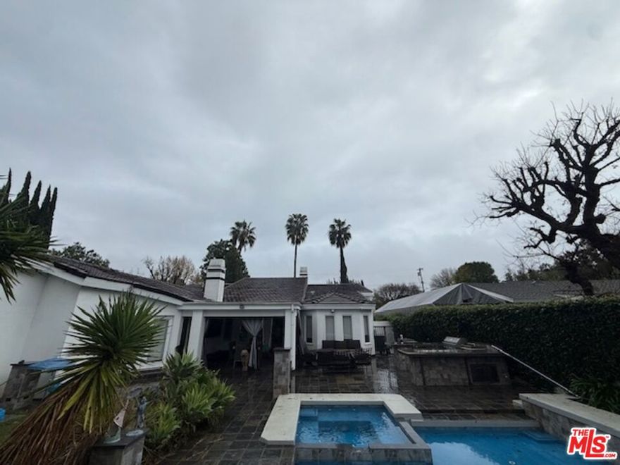 This stunningly reimagined private estate on nearly half an acre in Woodland Hills' prestigious College Acres is a true dream home, offering permitted 5,000 sq. ft. of luxurious living space. Fully gated and secure, the residence captures today's demand for the ultimate open-concept lifestyle. Highlights include 6 bedrooms, 6 baths, a home office with private entrance, Italian porcelain floors, and a projection-ready home theater/family room with soaring 14-ft vaulted ceilings and walls of windows. An art-gallery-style living room with a baby grand piano, a formal dining area, and an expansive family room make this home perfect for entertaining. Step outside to a Caribbean-blue Baja ledge pool and spa, landscaped flowering grounds, and dramatic smart lighting. Additional features include rare 360 ft of utility storage, plus inside and outside kitchens for effortless entertaining. The chef's kitchen is designed for gatherings, with a jumbo-size conversation island, integrated appliances, 22 ft quartz counters, sleek European cabinetry with pull-out drawers, stainless steel Viking commercial ovens and range, Sub-Zero refrigerator, oversized sinks, a vegetable prep sink, and a large walk-in pantry. Outdoors, host in style at the custom kitchen with grill and a 4-ft wall of fire centerpiece dining bar. Retreat to the junior master suites in separate wings, each with a private bath and a state-of-the-art shower. The luxury primary suite features a fireplace, spa-inspired marble bath with a six-jet tub and steam shower, and a spacious walk-in closet. A true resort-style estate blending elegance, functionality, and complete privacy. Buyer's agent and buyer are advised to perform their own due diligence on all information provided in this listing. Seller and seller's agent make no guarantees and shall not be held responsible for any inaccuracies.