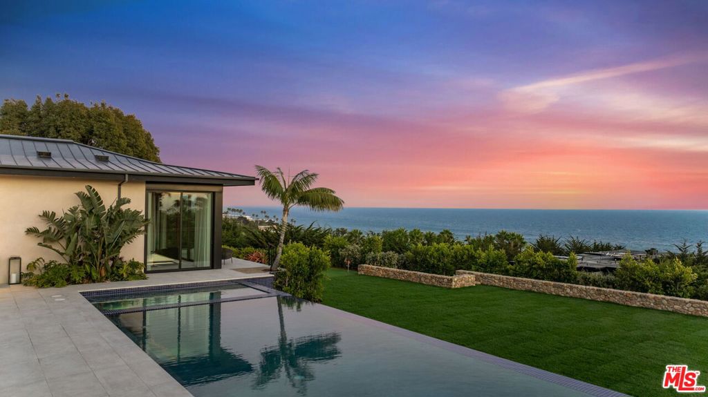 A palatial single-story estate influenced by the Four Seasons Hualalai brings resort-style living to Malibu. Set on two acres and designed by Doug Burdge, the compound features tennis/basketball court with pickleball, pool pavilion, gardens, two double garages, and the recently completed expansion of the flat backyard, which is on par with a sports pitch. Just a 20 minute drive from Camarillo Airport, the estate is one of 17 properties located in the exclusive 80-acre MariSol Malibu community. A Certified net zero carbon home that is 100% electric, featuring Tesla Powerwalls, solar panels, EV charging and endless eco-friendly features for a reduced carbon footprint. The main house is connected to the guest house via an interior glass bridge that is surrounded by lush tropical plants and ocean views. As you walk up the lanai steps and approach the grand front door entry you are welcomed with breathtaking ocean views stretching across the horizon. A perfect home for entertaining, the main kitchen is appointed with Miele and Gaggenau appliances, including three ovens, a built-in espresso machine and a reverse-osmosis water filtration system. Keep things clean up front with the secondary chef's prep kitchen, and enjoy the bar area with its four Gaggenau wine closets, beer tap and seating for six. The nearly 2,000 sq ft primary suite has whitewater views and sounds of the ocean waves. The suite includes a shou sugi ban water vapor fireplace, accoya wood ceiling, motorized doors and drapes, a large Poliform walk-in closet, a dual Porcelain-clad shower, and a rain-shower bathtub overlooking the ocean. This estate is a paradise for wellness seekers and includes a gym, steam room, Redwood sauna, water filtration system and a hospital-grade Merv 13 ventilation system. A verdant setting that's made to feel tropical, the exterior grounds include edible passionfruit, hibiscus and an organic fruit orchard and vegetable/herb garden. Offered fully furnished and decorated with art, the home is truly move-in-ready. Quick access to County Line surf break & beach, great seafood Neptune's Net Restaurant, and some of the best hiking trails in the Santa Monica Mountains.