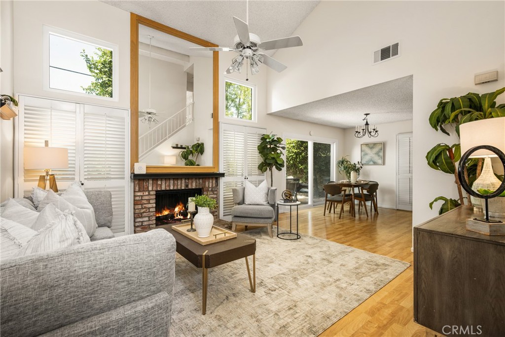 Featuring a sought-after location in the heart of Old Towne Orange, this rarely available attached, Single Family Residence end unit offers unparalleled convenience and charm. Nestled within the exclusive Hampton Court Gated Community, the well-designed open concept floor plan epitomizes the easy-living Southern California lifestyle. Step inside the well-maintained residence and discover a large welcoming living and dining area with vaulted ceilings and cozy gas fireplace, creating an inviting atmosphere for relaxation, and entertainment. Laminate floors flow seamlessly throughout the Living & Dining areas, leading to the sleek kitchen equipped with all the necessary appliances that the chef of the house would require. A Powder Bath is conveniently located on this level as well and easily accessible for friends and family. A French slider provides access to the private rear patio that is perfect for entertaining or simply unwinding after a hectic day with a chilled summer beverage or warm winter drink. Ascend the staircase to the second level and find two generously sized bedrooms, each with vaulted ceilings, both flooded with natural light. The full bath has recently been remodeled and is equipped with all the necessities. The attached garage has direct access to the home and provides convenient, secure parking for two cars as well as additional storage opportunities. Dual-pane vinyl windows throughout and upgraded HVAC provide extra comfort. HOA amenities include a large sparkling pool, spa, clubhouse, and manicured grounds. A few short blocks away enjoy the cultural and sporting events of Chapman University, Musco Center for the Arts, Hilbert Museum, MetroLink, and the many shopping and dining choices that the Old Towne Plaza District has to offer. Stroll the iconic Old Towne Historic District and marvel at the architectural treasures of the beautifully maintained homes. Welcome to Orange & the best it has to offer!