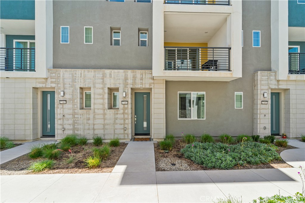 Experience elevated living in this stunning 3-bedroom, 4-bath townhome, ideally situated in the vibrant Five Points neighborhood's coveted Tulip tract. This home, built with premium builder upgrades has soaring ceilings, contemporary finishes, and an abundance of oversized windows that bathe the interior in natural light. The main living area boasts elegant, light-toned wide plank flooring, while plush Berber carpeting adds comfort to the bedrooms. The heart of the home is the chef's kitchen, featuring exquisite granite countertops, white shaker cabinetry, stainless steel appliances, and a generously sized island with ample bar seating, seamlessly connecting to the spacious living room with an oversized balcony, perfect for outdoor relaxation. Each bedroom offers a private en-suite bath and ample closet space, plus a convenient main-level powder room. The luxurious primary suite includes a large walk-in closet, a spacious en-suite bath with a walk-in shower and dual vanity, and a second oversized balcony. An upper-level laundry room adds to the home's convenience. A versatile lower-level bedroom with its own bath is perfect for a home office or guest suite. This smart home features solar panels, a tankless water heater, instant hot water, a smart water valve with leak detection, a smart stove, and an attached 2-car garage. The community HOA provides access to multiple pools with kiddie pool, spa, recreation center, community garden, and several parks. Enjoy proximity to award-winning schools, shopping, Magic Mountain, and easy freeway access.