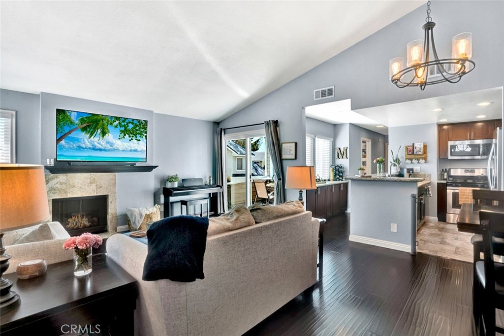 Nestled in the desirable community of Yorba Linda, this charming 2-bedroom, 2-bath end unit offers 1,010 sqft of living space. Host your guests all in one space with this open-concept family room and kitchen overlooking your private enclosed patio. The light and bright family room features vaulted ceiling and custom fireplace with wood mantle. Luxury-style kitchen offers custom cabinetry, recessed lighting, granite countertops, stainless steel appliances and adjacent custom dry bar, perfect for those toasting moments! The ambience of the dining area is set by a stylish chandelier showcasing Edison bulbs. The primary bedroom is light and bright with vaulted ceiling, generously-sized walk-in closet, and fully upgraded en-suite primary bath featuring custom stone tile walk-in shower with bench, recessed lighting, custom vanity with granite countertop, mirror, and upgraded hardware, upgraded lighting, and a custom pocket door for privacy. Designer secondary bedroom features custom built-in shelving, shiplap wall, wainscoting, custom wallpaper, and recessed lighting. The adjacent hall bath also features a custom vanity with granite countertop, mirror, and upgraded hardware as well as upgraded light fixtures. Additional storage in hallway linen cabinets. Two-car garage. Upgrades include Nest thermostat, upgraded double-paned windows and sliding glass door, window casings, hardwood-style and tile flooring, custom paint, tall baseboards, upgraded toilets, whole-house fan by Quiet Cool, and more! Enjoy walks on the greenbelt to the playground, community clubhouse, pool, spa, volleyball court, dog park, and nearby bike trail along the river.