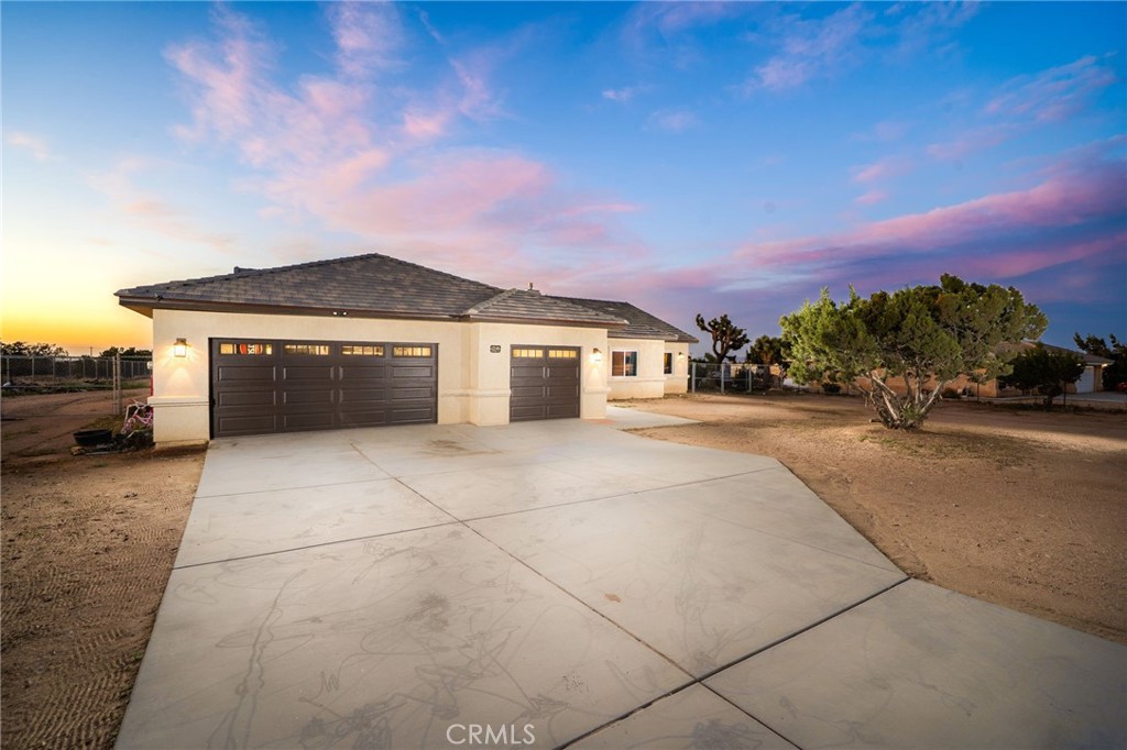 GORGEOUS OPEN CONCEPT SINGLE STORY OAK HILLS HOME. Welcome to this beautifully designed 4-bedroom, 2.5-bathroom home offering 2,435 square feet of thoughtfully crafted living space, all situated on a spacious and usable 1-acre flat lot. From the moment you walk through the front door, you’re greeted by a warm and inviting great room featuring a stunning stone fireplace with a custom mantel—perfect for cozy evenings at home. The kitchen is truly the heart of the home, with a large quartz island that includes a deep sink and storage on both sides—ideal for entertaining or everyday living. You'll find black stainless steel appliances, an abundance of cabinetry, and a generous walk-in pantry that checks every box for functionality and style. Throughout the home, you’ll notice recessed lighting, wood-look porcelain tile flooring in main living areas, plush carpet in the bedrooms, and ceiling fans for added comfort. There's also a spacious indoor laundry room and a mudroom ?right as you enter from the garage that adds to the home’s practicality. The primary suite is a standout, featuring a spa-like bathroom with dual walk-in showers, his-and-hers sinks, a dedicated vanity with an LED mirror, and two walk-in closets. Outside, the stucco-covered patio and outdoor ceiling fan create a comfortable space to relax or entertain, especially on warm summer days. Plus, you have a?n attached and finished 3-car garage? for all the vehicles and toys. Located just minutes from Ranchero Road and the 15 Freeway, this home offers easy access for commuters, and it’s conveniently close to schools and shopping. It’s the kind of home that checks all the boxes—style, space, and smart features throughout.