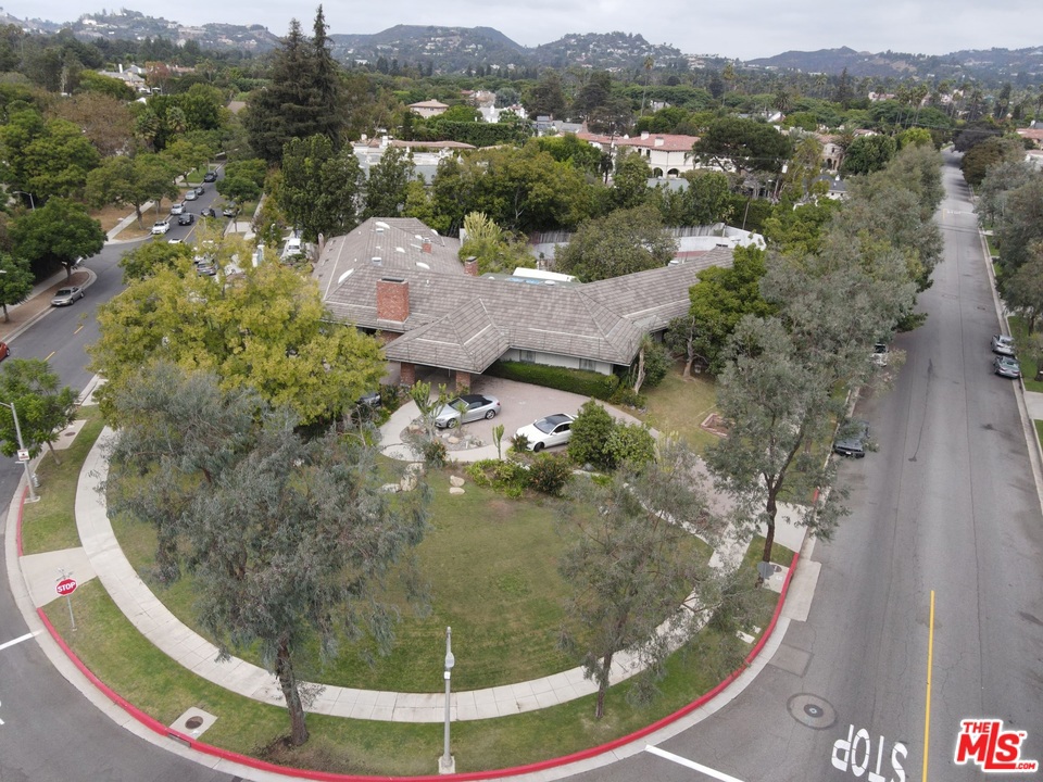 Celebrity Landmark Estate redo or Build your Palace. Sprawling 7 br, 9 ba, formal dining rm can seat over 30, huge family rm with bar and pool table, library, separate guest facility, sunken Tennis Court with stadium seating, lagoon Swimming Pool. Lovely porte cochere entry with 6 car off street parking. Magnificent Opportunity to build a grand showplace in the west end flats of Beverly Hills. Sprawling One+ Acre Corner lot on Whittier at the end of Lomitas, across from the Los Angeles Country Club. Call your builders, developers, and those searching for Trophy Location to build. Existing 7700+ square foot single level house built 1952. Large Circular Driveway. Two additional Driveways and 3 car Garage.