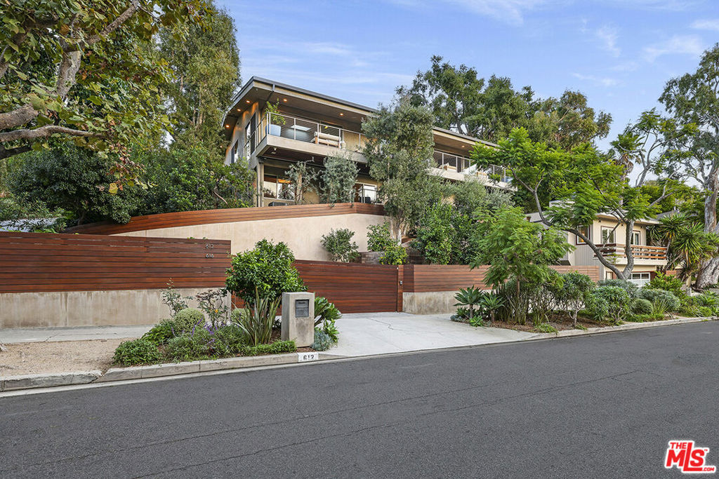 Welcome to this impeccably designed, warm contemporary residence nestled in the coveted Santa Monica Canyon. This special property is fully gated and is surrounded by mature landscaping, including a multitude of fruit trees, and encompasses a main house (4176 s/f) plus a two-story guest house (1354 s/f) and an additional guest house (553 s/f). As you enter the gate, you'll be greeted by elegant communal spaces including an outdoor kitchen with pizza oven, dining area, lounge space with cozy fire pit and water feature that meanders into a relaxing spa. Every detail of this property has been meticulously crafted with a focus on high-end luxury, including floor-to-ceiling Fleetwood sliding glass doors that invite abundant natural light inside and seamlessly connect indoor and outdoor. Upon entering the main house, you are enveloped in warmth and light throughout the main living area. The chef's kitchen has an expansive island with plenty of room to prep, cook and entertain, including Miele appliances. The open floor plan allows for plenty of gathering areas and dining options. Also, on this floor is the gorgeous primary suite that evokes the ambiance of a luxurious spa retreat which features a walk-in closet and bathroom with steam shower, spa tub and dual vanity. Additionally, there is an office area off the entry which would make for the perfect den. On the level below are two additional bedrooms each with ensuite bathrooms, a home theater, additional family room space perfect for homework and play and the laundry with two washers and dryers. For guests or additional living/office space, the property is complete with 2 separate guest dwellings. The two-story architectural guest house features a private garage which is used as a gym, living room and kitchen and full bathroom on the ground floor, and upstairs bedroom and full bath with bonus area. A secondary guest house offers a bedroom, bathroom, and a well-appointed kitchen, and has a private entrance. To complete this property, there are three 2-car private garages. This expansive estate epitomizes the essence of luxury living while ensuring your utmost privacy.