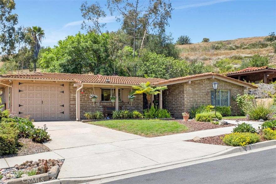 Welcome to Authentic Adobe Living at 3331 Via Altamira, a captivating 2-bedroom, 2-bathroom adobe home in the desirable Pala Mesa Village community of Fallbrook. With 1448 sq. ft. of thoughtfully designed living space, this home exudes classic Spanish charm, featuring adobe construction, hand-carved doors, exposed beam ceilings, and traditional kiva fireplaces that add rich architectural character throughout.  Enjoy great room-style living, where the spacious main living area is centered around a stunning fireplace—the heart of the home and perfect for cozy gatherings. The galley kitchen is located just off the main living area, adjacent to the garage and laundry/storage room, offering both convenience and functionality.

The picturesque dining room features oversized windows that beautifully capture the indoor-outdoor living experience, filling the space with natural light and views of the tranquil surroundings.  Step outside to two private backyard patios, ideal for relaxing or entertaining while taking in the tranquil beauty of nature and the surrounding hills.  Set in a quiet neighborhood with lush, mature landscaping, Pala Mesa Village offers resort-style amenities including a Hacienda-style clubhouse, saltwater pool and spa, sauna, billiard room with library, putting green, shuffleboard, scenic walking trails, and more.  Conveniently located near Hwy 76 and I-15, and within the Bonsall School District, this unique adobe home offers timeless charm, natural beauty, and a true sense of community.