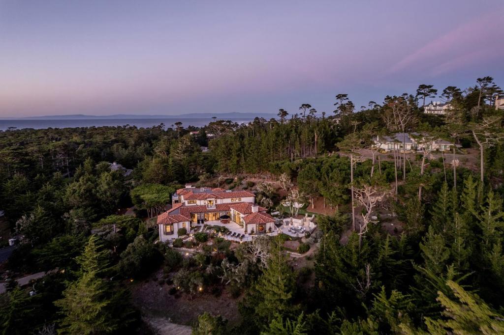 Located on Pebble Beach's renowned 17-mile drive near the world-famous Lone Cypress, this breathtaking estate on 2.6 private acres includes an impressive list of luxuries and the highest quality materials and construction. The modern Mediterranean home faces southwest, allowing natural light to spill through floor-to-ceiling windows and expansive outdoor living spaces to watch the sunsets. Highlights include 5 bedrooms with a luxurious primary suite, 5 full/2 half bathrooms, a full guest /caretaker's apartment with its own private parking and keyed entrance, a putting green, 9 custom stone fireplaces, soaring ceilings with exposed beams, a gourmet kitchen with breakfast bar/island and 2 Bosch French door wall ovens, elevator access to all 3 floors, AC and full house generator, bonus rooms, a smart home system, and beautiful filtered ocean views throughout most of the home. With ~10,000 SqFt of comfortable living space, this is a rare offering for turnkey, modern living in Pebble Beach.