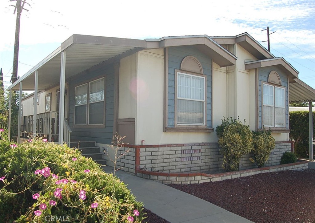A Charming Traditional Doublewide Home with Spacious Layout! Welcome to this beautifully maintained 3-bedroom, 2-bath doublewide manufactured home, built in 2002, featuring a warm traditional design and with a bright, open floorplan. Step inside to discover a spacious living room and formal dining area—perfect for entertaining or everyday comfort. The open-concept kitchen is equipped with ample cabinetry, a breakfast counter, and easy access to the adjacent indoor laundry room for added convenience. The primary suite is a true retreat, offering a private bathroom with a luxurious Roman-style soaking tub, separate shower, and dual-sink vanity. Enjoy the natural light pouring in through an abundance of windows, enhanced by recessed lighting throughout the home. Outside, relax on the expansive covered front porch or take advantage of the extended carport, storage shed, and a small private rear yard—ideal for gardening or pets. Located in a well maintained community w/Low space Rent and with community amenities inc a pool and club house. Don't miss this opportunity to own a move-in-ready home with space, style, and comfort!