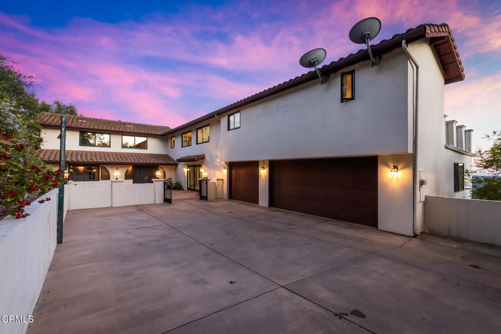 Set behind private gates on over an acre of land, this updated and secluded residence offers an exceptional blend of privacy, tranquility, and sweeping views of the city skyline and surrounding mountains. Thoughtfully designed to accommodate both large-scale entertaining and comfortable everyday living, the home welcomes you with a spacious front patio and a gracious formal entry. Inside, the expansive living room features soaring ceilings, a dramatic stone fireplace, and direct access to a view deck, an ideal space for seamless indoor-outdoor entertaining. A separate family room, outfitted with custom built-in bookshelves and a wet bar, also opens to the deck and provides a warm, inviting space with breathtaking vistas. The remodeled kitchen is equipped with a generous center island with seating, top-of-the-line stainless steel appliances, and connects effortlessly to the adjacent dining room, perfect for both formal occasions and casual meals. The main level offers two bedrooms, including one that is ideal for use as a home office. Upstairs, accessible both by stairs and an elevator, are six additional bedrooms, including two luxurious primary suites. The main primary retreat features its own private patio with captivating views of Downtown Los Angeles, while the second primary suite enjoys a private balcony. A well-appointed laundry room completes the upper level for added convenience.Located at the border of La Canada Flintridge and Glendale, this extraordinary home offers easy access to the best of both communities. Additional highlights include an 830 SF three-car garage and a sauna, enhancing the home's balance of function and comfort. Blending timeless design, refined updates, and unmatched views, this exceptional estate presents a rare opportunity to enjoy space and serenity.