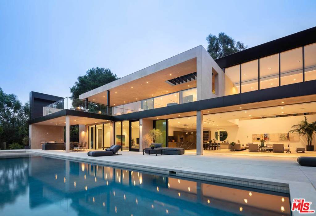 Constructed with the finest of materials and an innovative design, this contemporary estate offers the opportunity to live within a work of art while holding a coveted Beverly Hills address. Located along the verdant hillside of Benedict Canyon, this master work home by Viewpoint Collection is highlighted by its lush green vantage points across the canyon, intricate architectural details, and uniquely inspired amenities, while offering an ease of access to all of Los Angeles. Newly rebuilt with the finest craftsmanship, the home includes five bedrooms and 5.5 bathrooms, spanning over 6,500 square feet. Secluded behind a private gated facade, the modern concrete and stucco exterior gives way to a warm interior filled with natural woods, imported stone, dramatic ceilings, and expansive glass walls to take in the lush hillside views. A double-height great room for living and dining lies next to a gourmet kitchen, sunken television room, and secondary office/bedroom, all with access to the expansive terrace and oversized pool with spa. All of the bedrooms and bathrooms have been outfitted with designer finishes and luxe fixtures, with the primary en-suite in particular featuring a spa-grade bathroom, dual custom closets, and a private 1,500-square-foot balcony complete with a fireplace and wet bar. Underneath the pool, a secondary area with its own address has been built out with a separate entrance, kitchenette, bathroom, and steam room. Rounding out the property are additional features such as best-in-class smart-home systems, an electric vehicle charging station within the attached garage, a poolside outdoor kitchen, and availability for solar panels, if desired. Ultimately, this property was intuitively crafted with luxury comfort and ease of entertaining in mind, allowing for unforgettable intimate gatherings and one-of-a-kind casual affairs of all scopes and sizes.