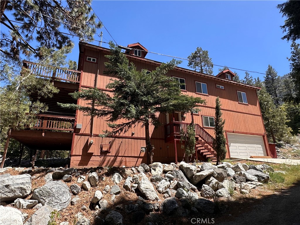 Custom Built Beautiful Home on quiet street has much to offer. Surrounded by trees and sitting up high on the banks of seasonal Snow Creek. Upgraded with modern dual glazed windows for comfort and allows one to enjoy the spectacular views. Freshly refurbished w/ new paint, trim and flooring throughout. In the middle of the glorious San Gorgonio Wilderness & just steps away from Southern California's tallest year 'round waterfall Big Falls. Access not only to Mill Creek but several great hiking trails. Covered entry leads into huge bright living room with soaring ceilings. On south side sits office/den/guest bedroom with French door entry and nearby full bath. Direct access to garage from this side of the home makes it very convenient to unload groceries to directly into home. Living room has floor to ceiling fireplace for warmth and ambiance on those chilly mountain evenings. Large open kitchen has bright white counter tops and a well placed island to satisfy even the pickiest of cooks and Bakers. Tons of cabinets for plenty of storage. Big windows over the kitchen sink makes it pleasurable to look at when doing dishes. Balcony off kitchen hosts more stunning views.
Upstairs features two big bedrooms and a full bath off convenient sitting room which also has a cozy fireplace for warmth and enjoyment. Master suite off upstairs family room is spacious and comfortable has its own full bath, soaking tub, detached shower and private throne. Wrap around deck accessible from both master and living room calls to set a spell and enjoy the sites. Water is crisp, clean, unlimited and unmetered, has no chemicals and a share comes with purchase of home.