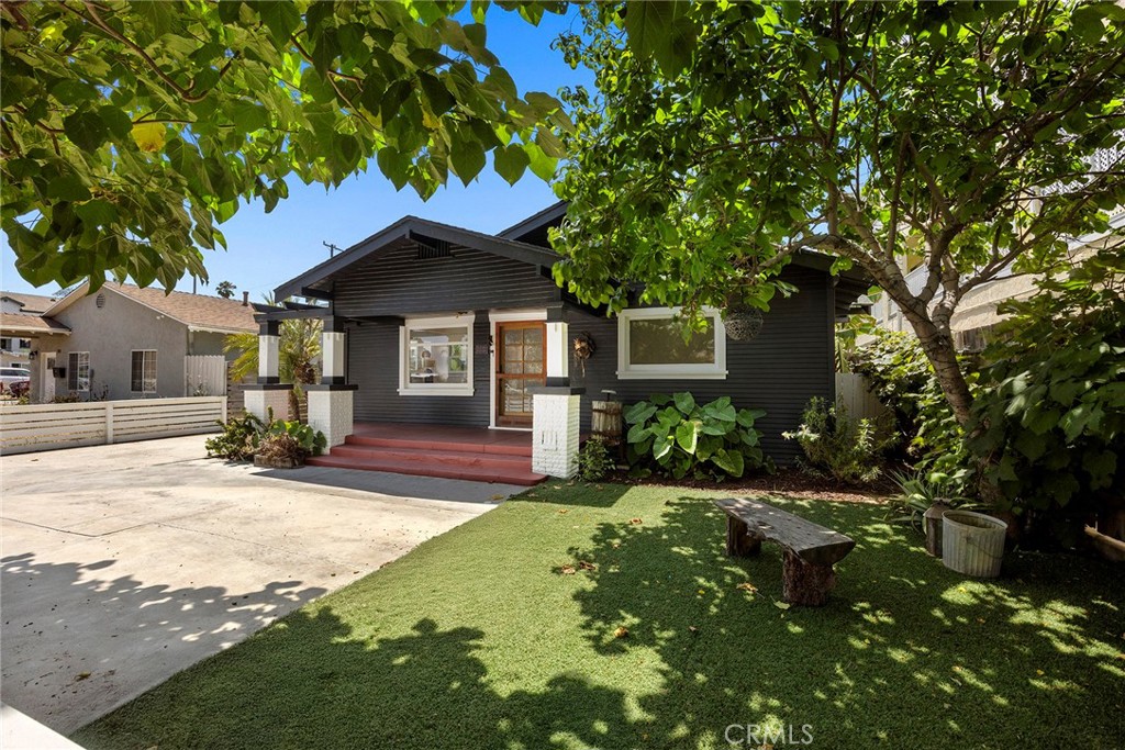 Welcome to this beautifully preserved and thoughtfully updated 3-bedroom, 2-bath Craftsman-style home, offering a perfect blend of vintage charm and contemporary convenience. Ideally located less than two miles from the beach and Bixby Park, and just blocks from Rose Park and a variety of popular dining destinations, this home offers the ideal blend of character, comfort, and coastal living. Inside, you’ll find updated flooring, large windows that flood the space with natural light, and a seamless open-concept layout between the living and dining area, perfect for gatherings and entertaining. The updated kitchen features classic white shaker cabinets, soft close drawers, butcher block countertops, a farmhouse sink, stainless steel appliances (including a dishwasher, microwave and refrigerator), and recessed lighting. Enjoy true indoor-outdoor living with three access points to the expansive, landscaped backyard, via the dining room, one of the bedrooms, and the kitchen. The outdoor space is a TRUE SHOW STOPPER! This magical space offers multiple areas to relax and unwind, including a spacious step-up front porch, a cozy side porch off the dining room, and a back porch that opens to a peaceful yard with a wood deck, covered gazebo with grape vines, and a convenient outdoor laundry room. A standout feature of this home is its rare 6,493 sq ft lot, offering more space than most Long Beach properties. This oversized lot gives you added privacy, versatility, and incredible potential for future expansion. The beautiful lush and mature plants truly transform this space and give you privacy. The property inlcudes, Banana tree, accorn tree, lemon, lime tree and grape vines in the front and backyard. The primary suite includes a en-suite bathroom, and two walk in closets. One of the secondary bedrooms features original built-in shelving and dresser drawers, adding charm and historic character. Additional upgrades include split duct heating and air, a freshly painted exterior, and paid-off solar panels for energy efficiency. A long driveway leads to the detached garage with alley access, offering endless possibilities as an ADU, guest house, office, gym, or creative studio. This rare gem captures the soul of 1920s architecture while embracing the modern lifestyle you’ve been dreaming of.